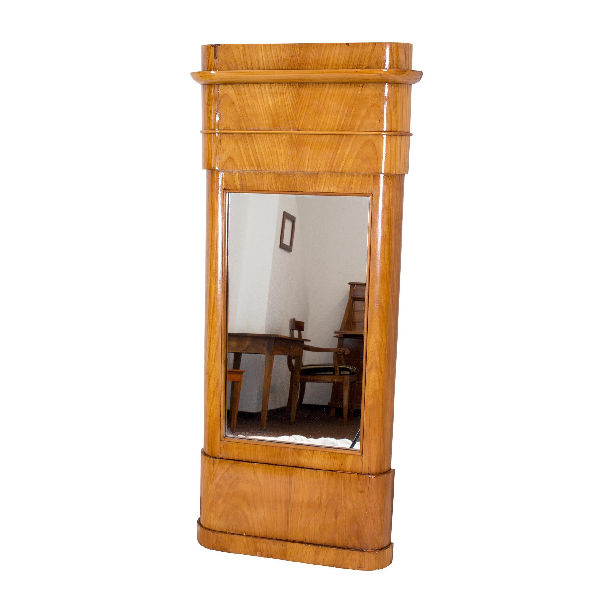 The mirror dates from the Biedermeier period and was made from cherry wood and spruce. Very nice soft edges. The mirror glass was replaced at some point and the mirror is still in good condition. Very good restored condition.