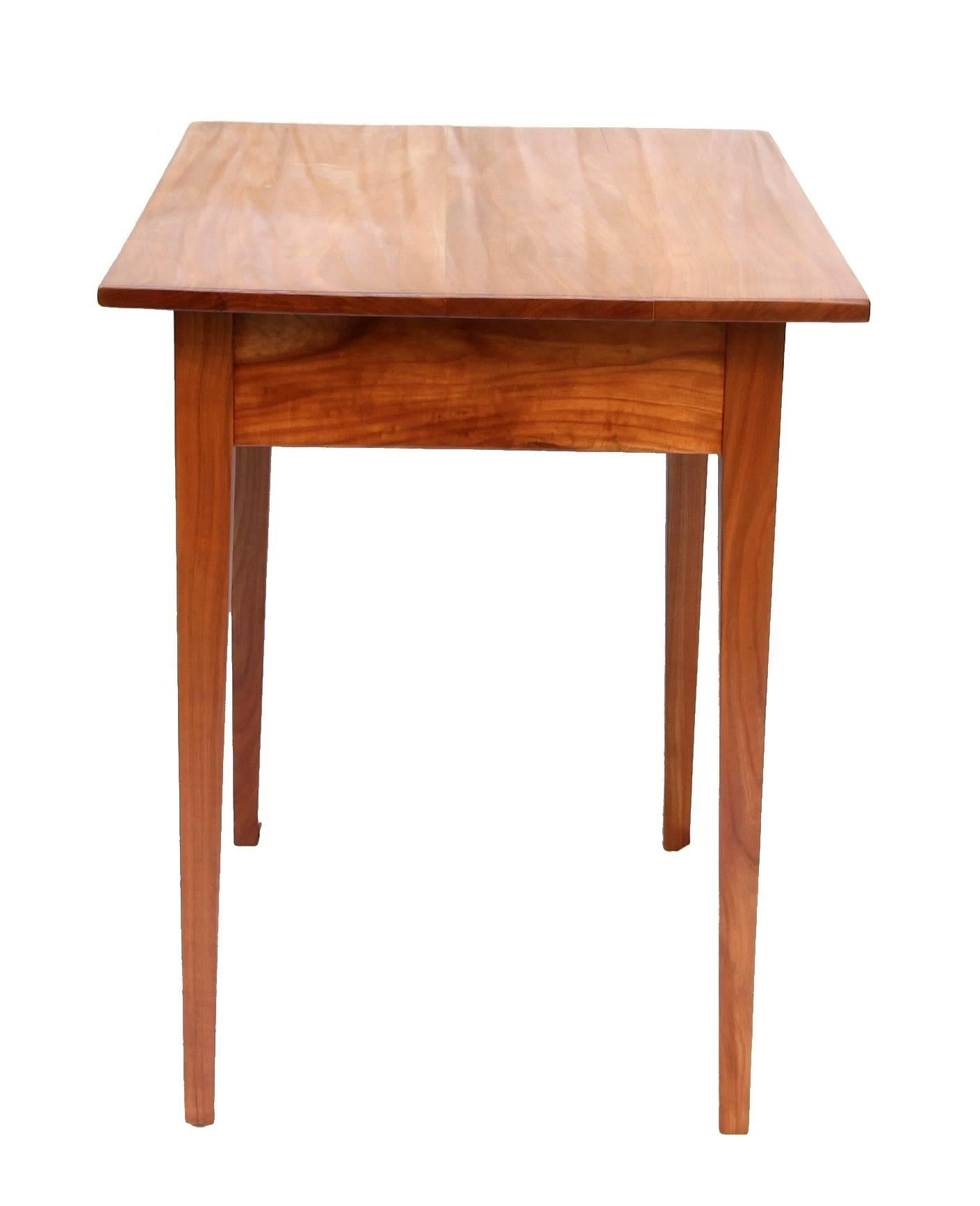 The side table is made of solid cherrywood and has a wonderful timeless design, dates back to the time of Biedermeier, circa 1825. The drawer is, as usual, made of pine wood, the panel of cherry.