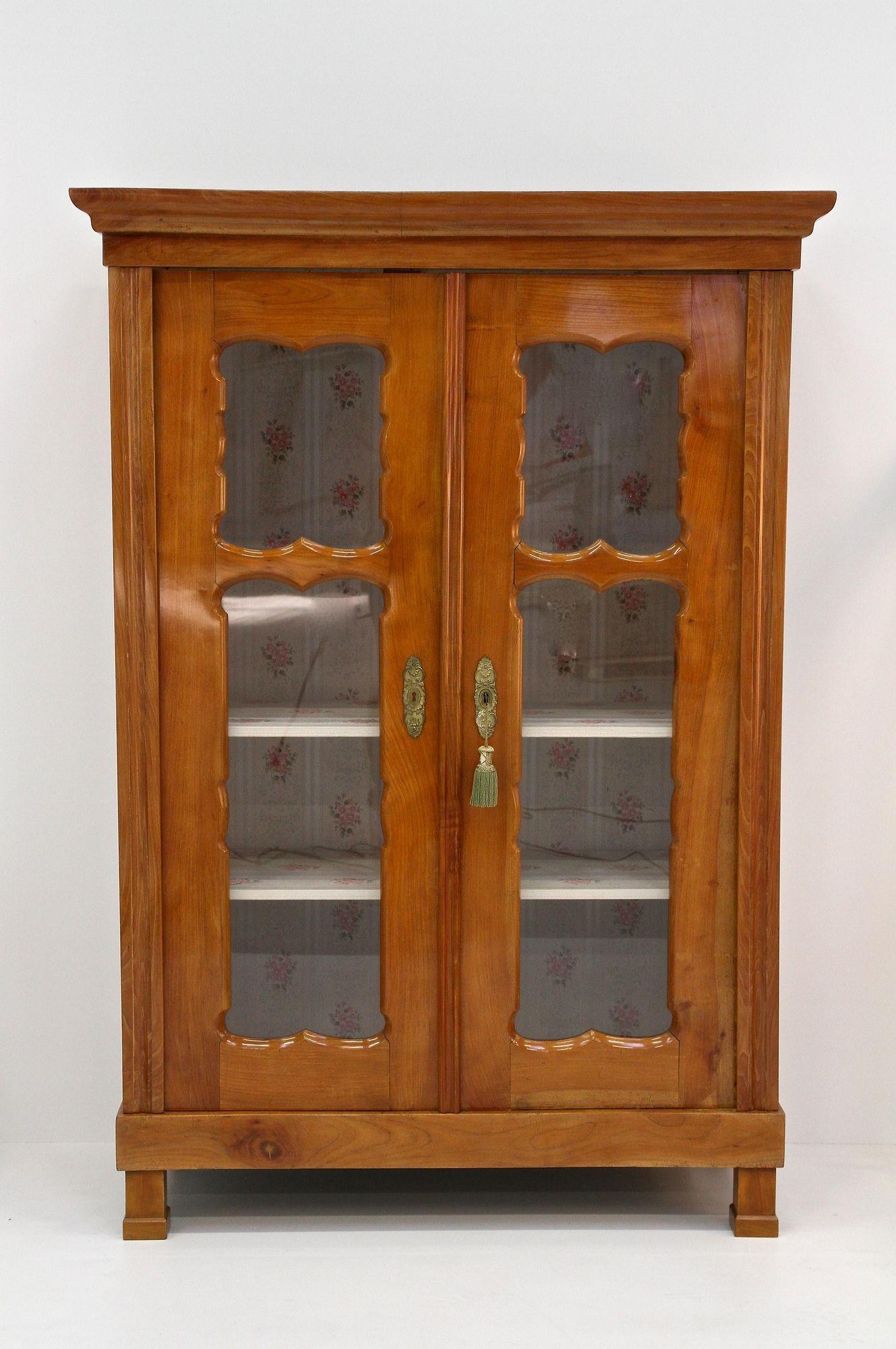 Bellissimo mobile vitreo in legno di noce Biedermeier restaurato, elaborato a mano nel famoso periodo intorno al 1840 in Austria. Il corpo in abete massello presenta una superficie impiallacciata in ciliegio dall'aspetto sorprendente, con venature