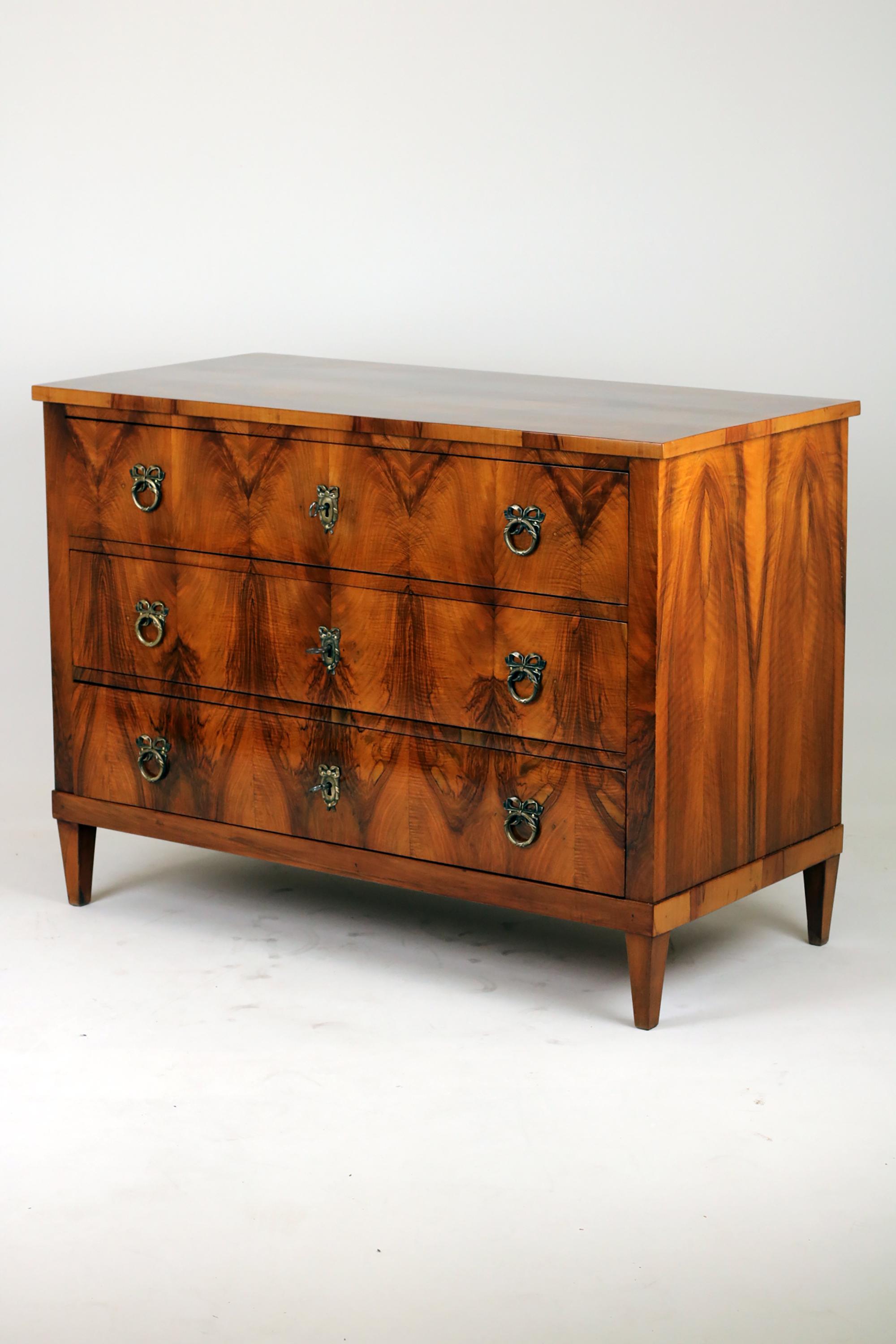 Early 19th Century Chest of drawer, 
Germany 1820, of the Biedermeier period

Very impressive Biedermeier Chest of drawers, standing on conical feet with beautifully walnut veneer.  The top plate mirrored, pyramid-shaped veneer. Three large drawers