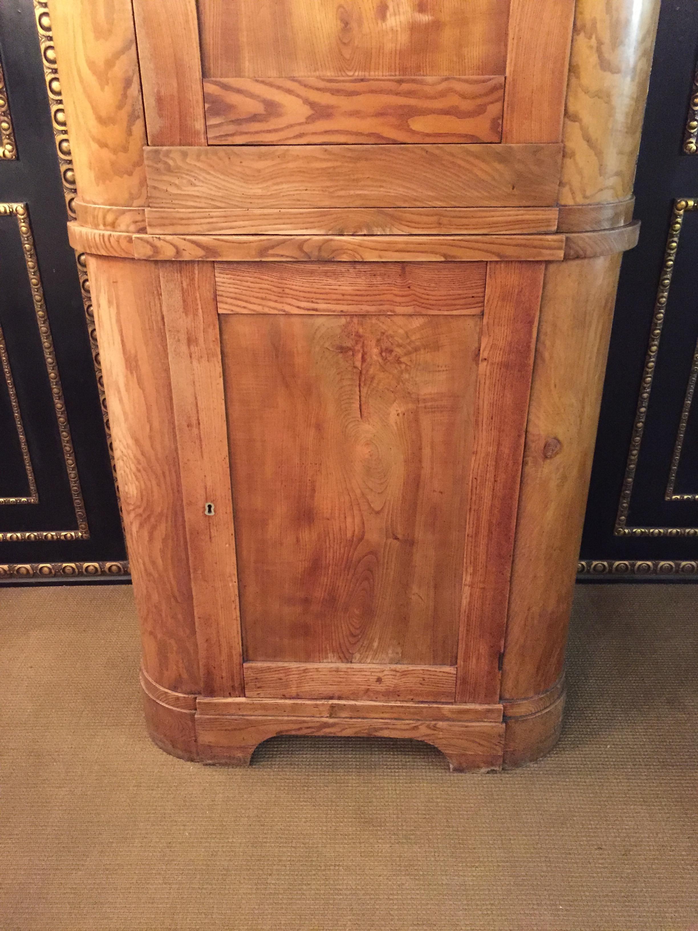 Large Biedermeier corner cupboard in ash.
2 large double doors behind each 2 shelves.

As can be seen in the pictures there are old worm extinguishers in the upper door panel, which of course are no longer