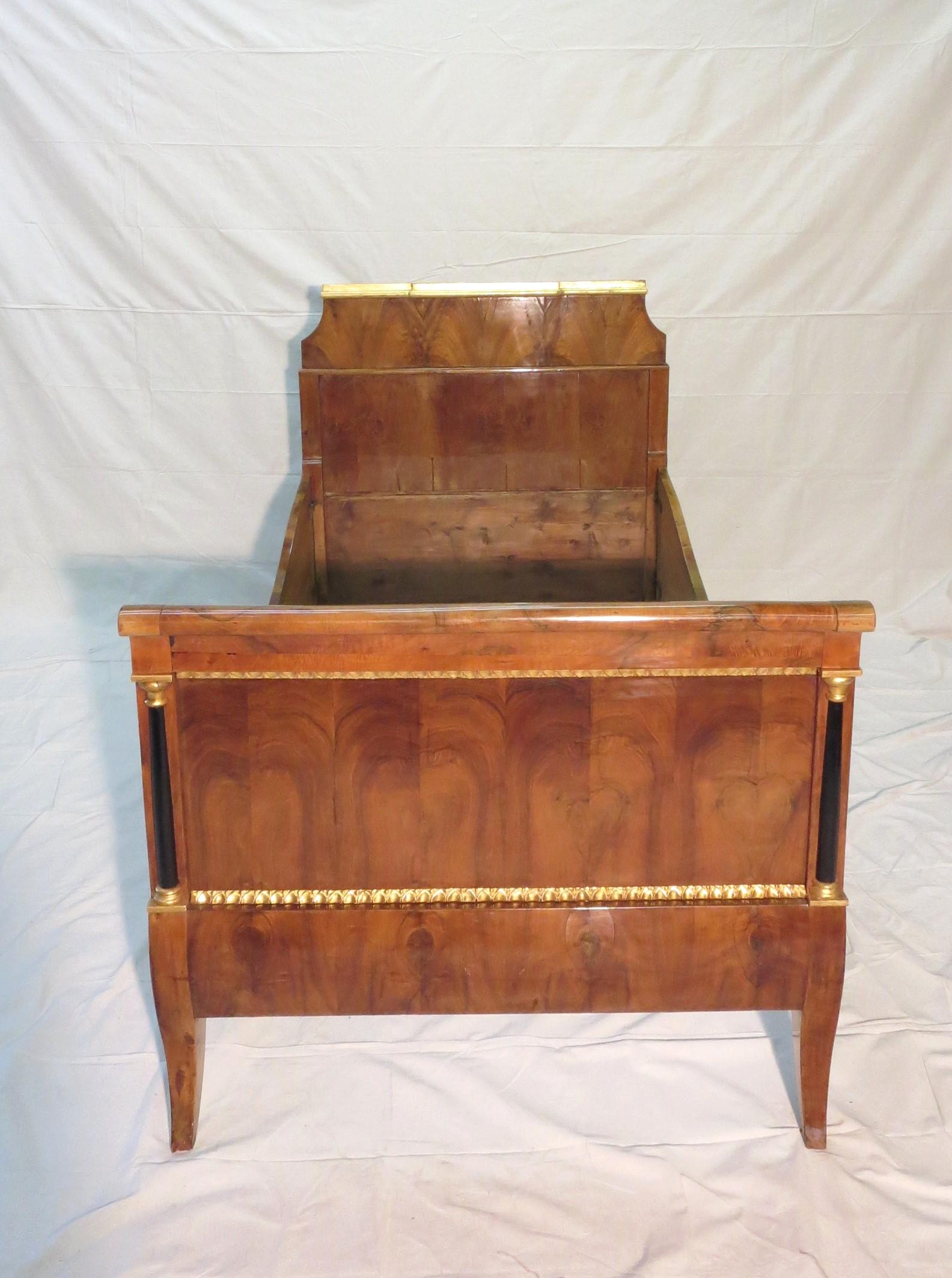 19th Century Biedermeier Directoire style Twin Daybed Walnut & Gilded decoration . This bed has gilded designs and ebonized columns with exceptional Workmanship. Exquisitely detailed gilt trims. An incredible find for your interior design and to
