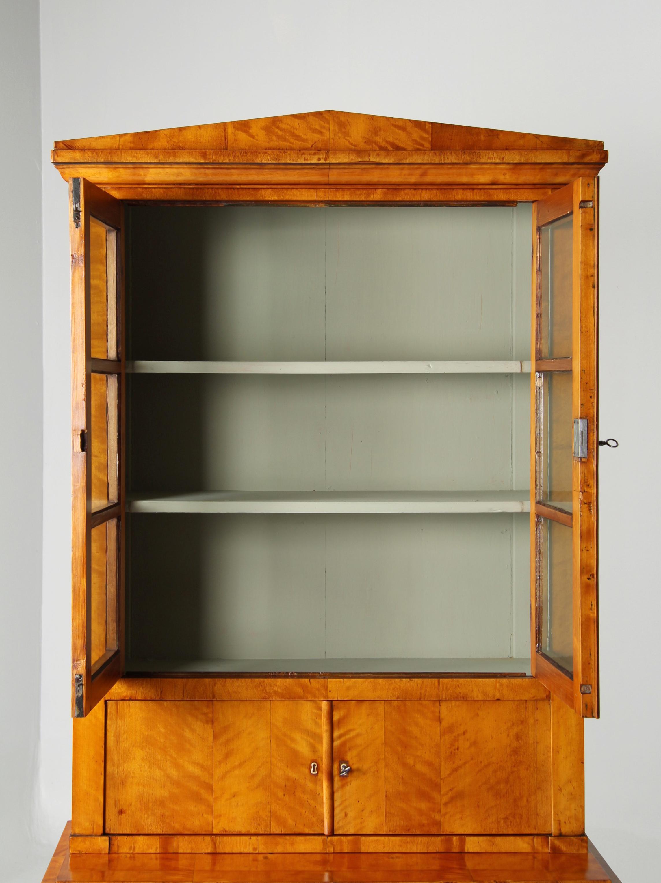 Biedermeier Display Case

Northern Germany
Birch
Biedermeier around 1835

Dimensions: H x W x D: 209 x 99 x 53 cm

Description:
Very slim Biedermeier top-mounted furniture with a three-drawer chest of drawers and a four-door top.

The flamed birch
