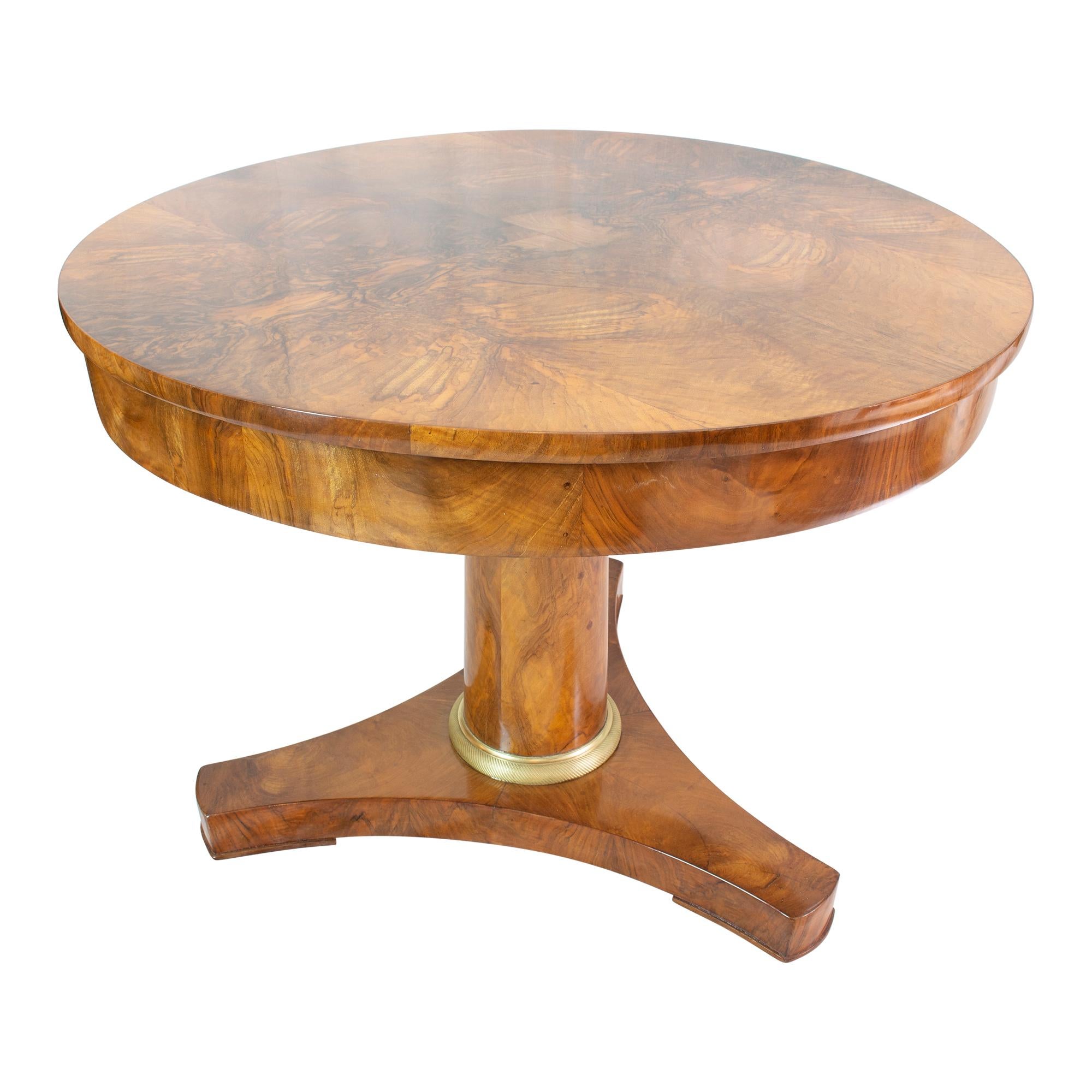 Beautiful round salon table from the Biedermeier / Empire period around 1815. The table is covered with thick walnut saw veneer. The veneer is mirrored several times and thus creates a beautiful veneer pattern. The table has a unique construction