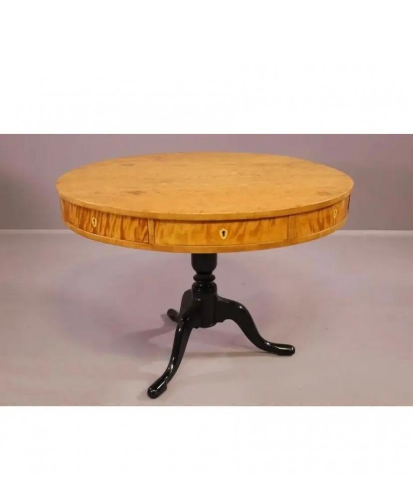 Wooden game table with 40-inch circular table top and black pedestal legs. Working drawers accented with gold hardware. Ebony tripod legs with curving feet.