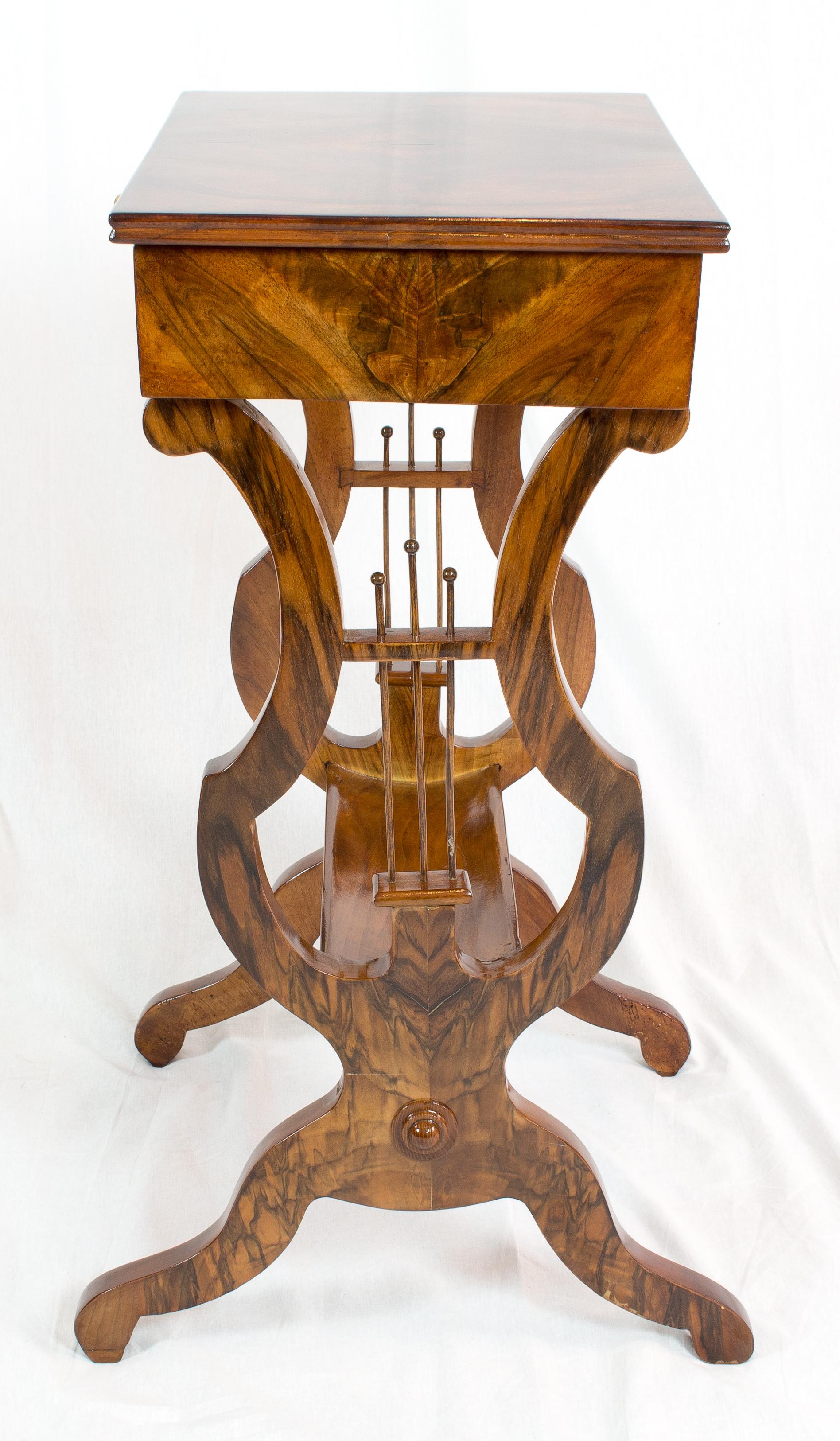 Beautiful Lyra sewing or side table made of walnut solid and veneer. The table dates back to the time of Biedermeier period, more specifically from the time, circa 1825. In very good restored condition.