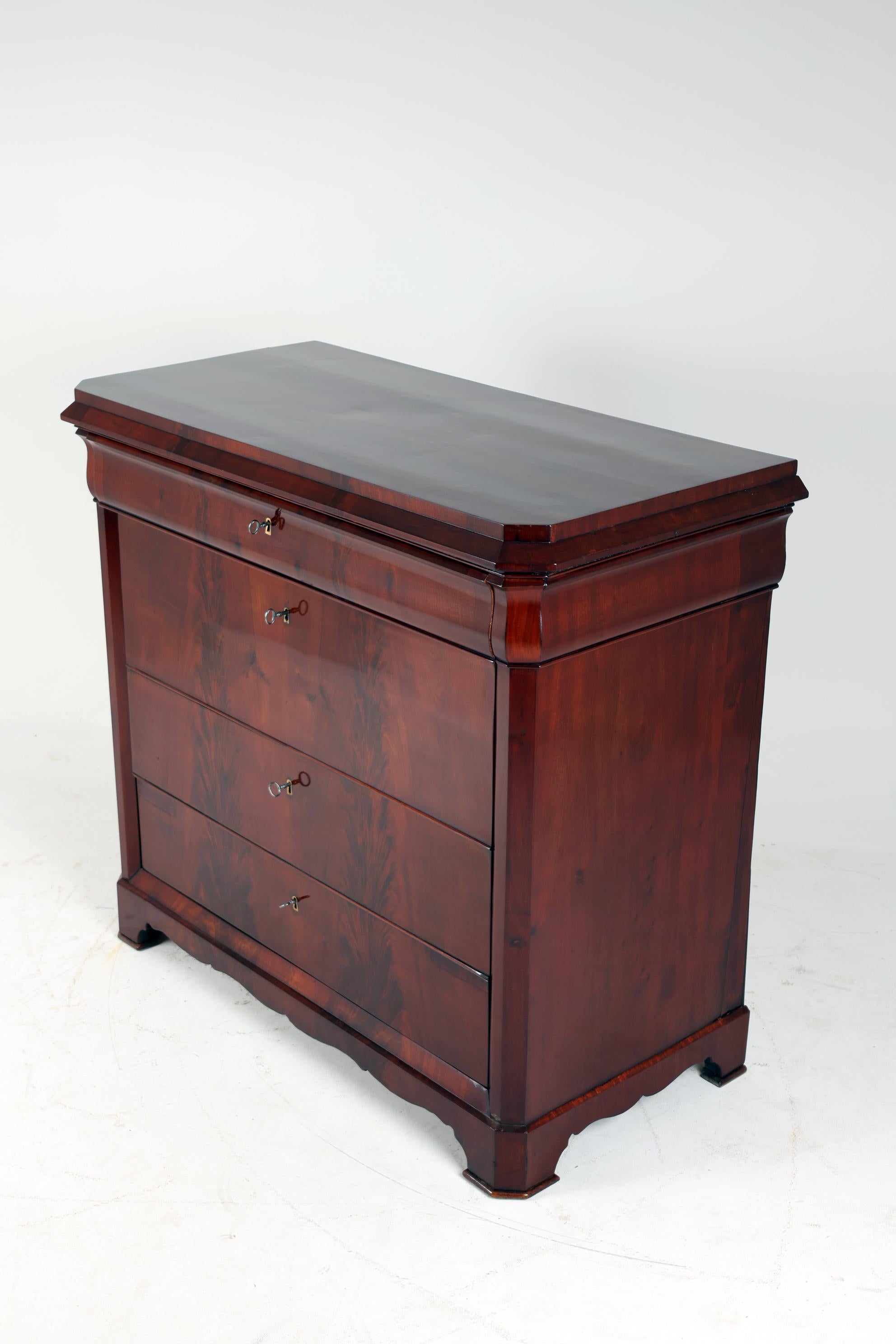 XIX Century Biedermeier Chest of Drawers,
Germany, 1830-1835
Mahogany

Biedermeier Chest of Drawers with spectacular mahogany veneer which is laid absolutely symmetrically and runs across the entire front of the furniture.
Four drawers with discreet
