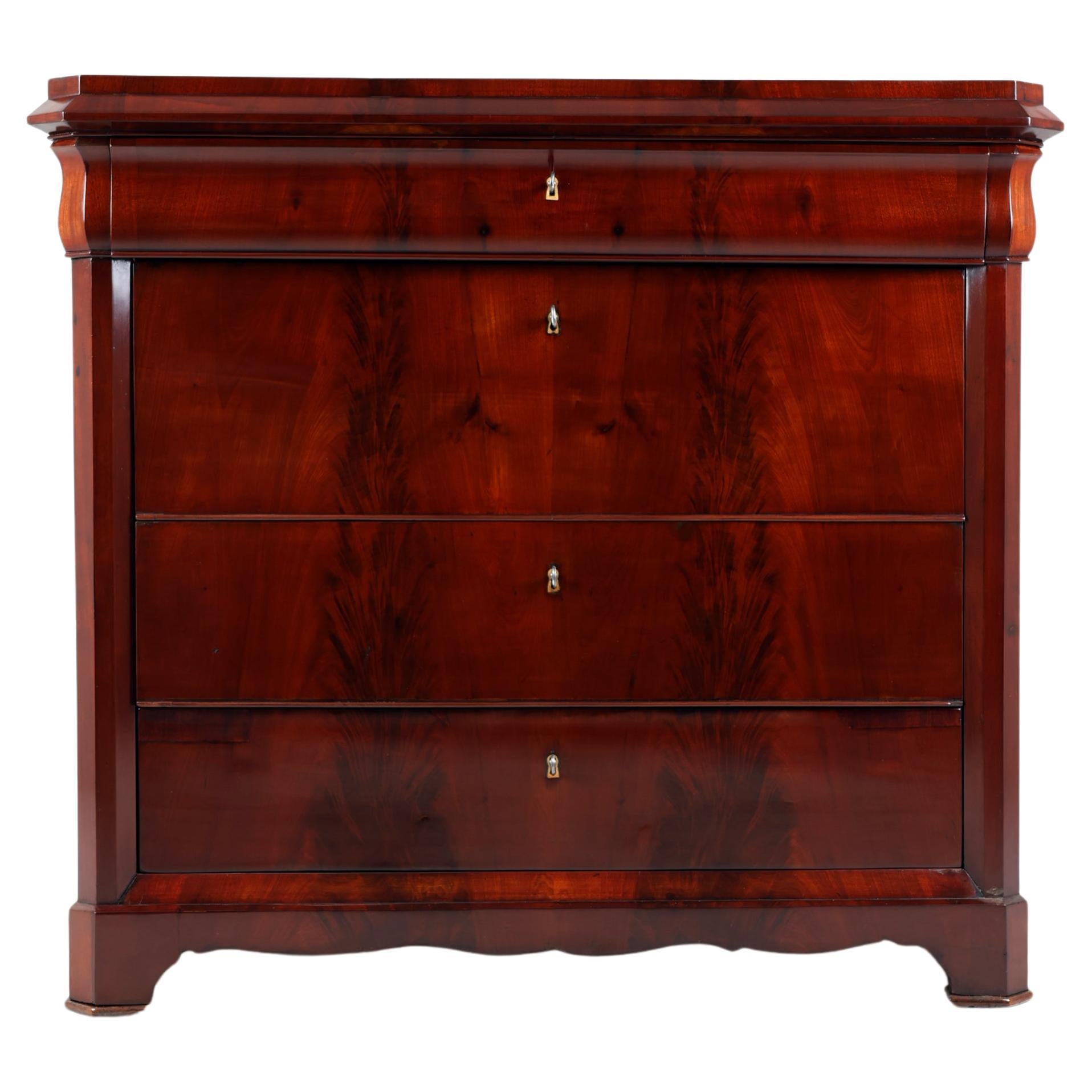 XIX Century Biedermeier Chest of Drawers,
Germany, 1830-1835
Mahogany

Biedermeier Chest of Drawers with spectacular mahogany veneer which is laid absolutely symmetrically and runs across the entire front of the furniture.
Four drawers with discreet