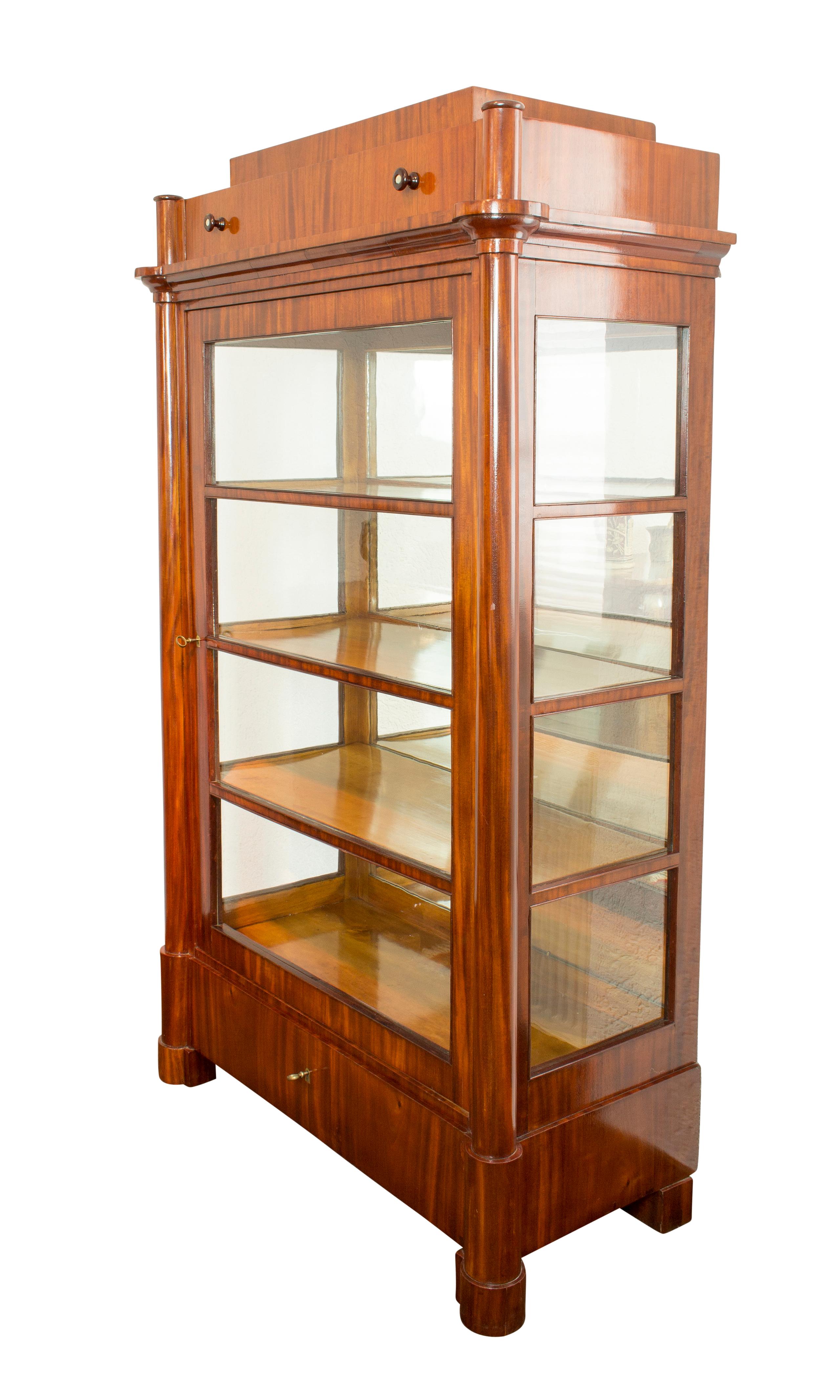 Very nice showcase with 3 sides glass. The showcase is from the time of the Biedermeier from Germany, Berlin. The showcase is made of pine wood covered with nutwood veneer. The shelves are made of birch wood, which has a very nice contrast to the