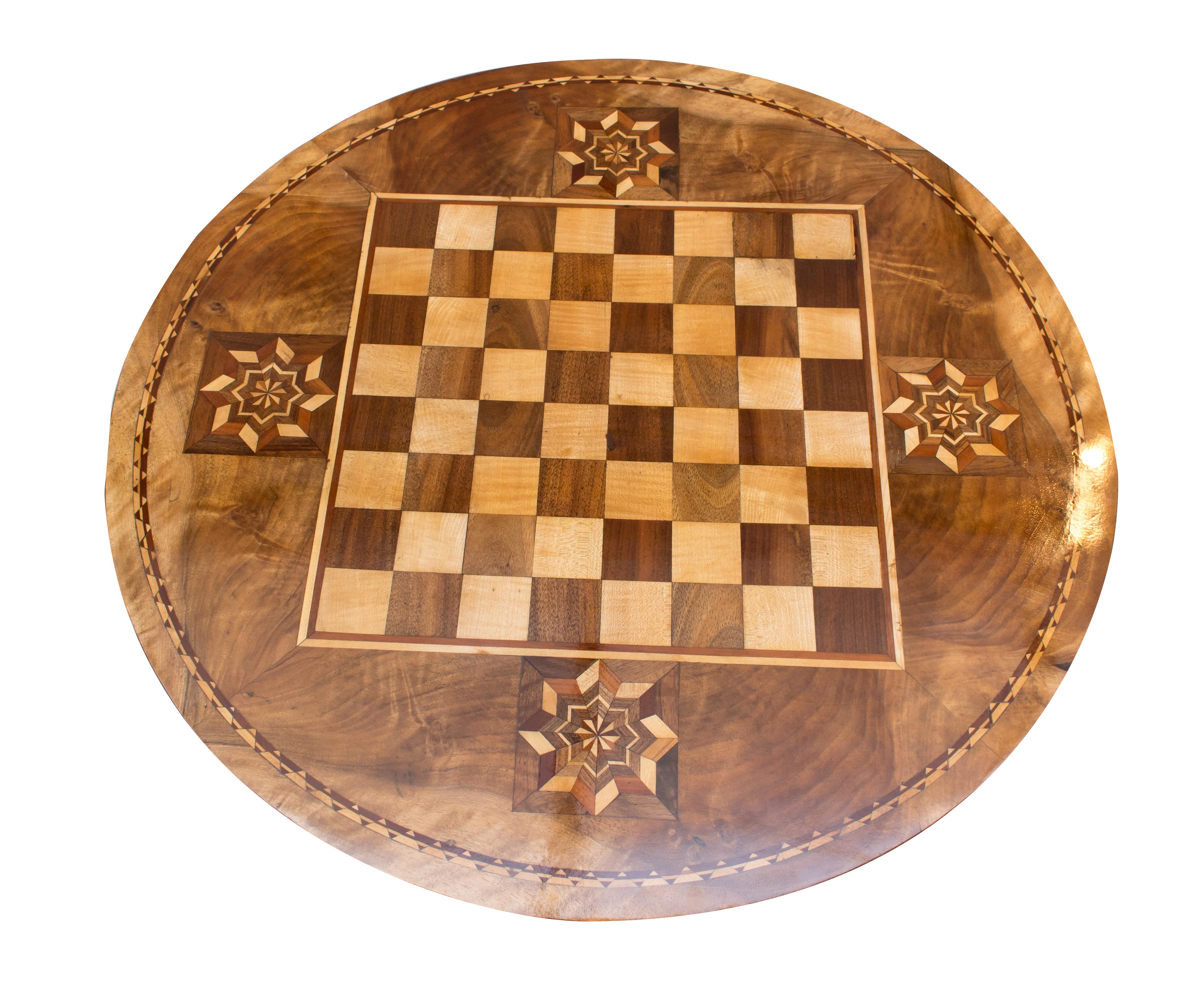The table stands on a central baluster column which itself rests on three booms at the bottom. The tabletop with a decorated chessboard is a very beautiful marquetry work. The foot is made of pear wood, the table mainly of walnut with various fruit