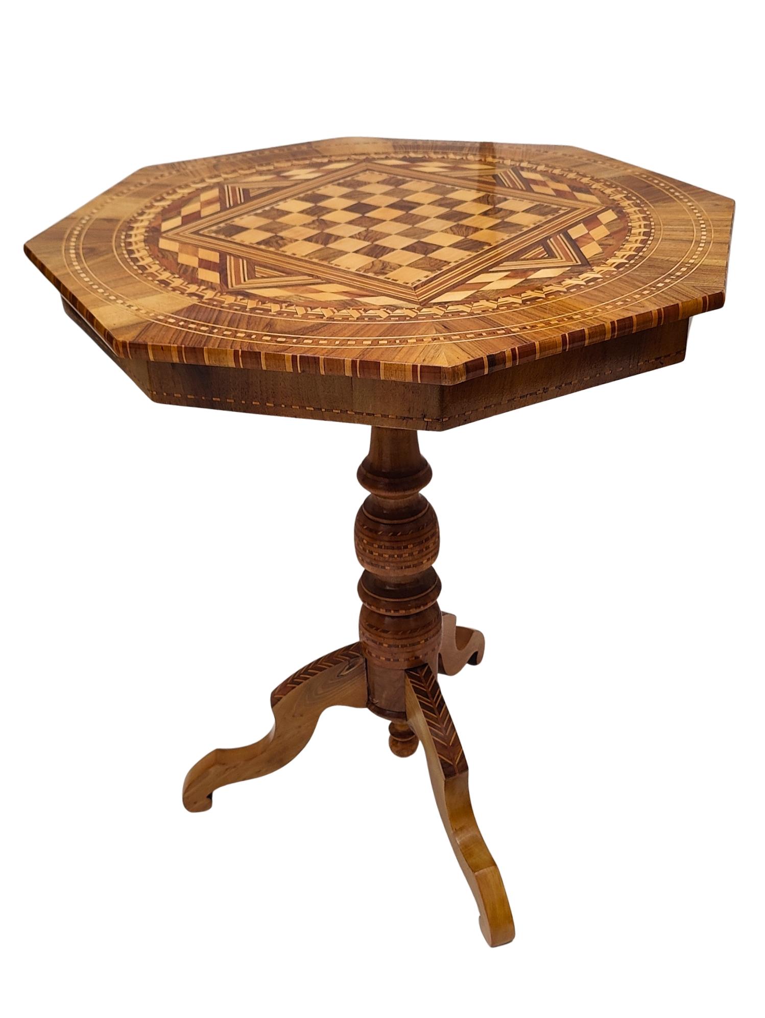 This elegant octagonal game table dates back to around 1830 and impresses with its intricate marquetry work and timeless craftsmanship. The tabletop features a detailed chessboard made from various fine woods, framed by elaborate geometric and