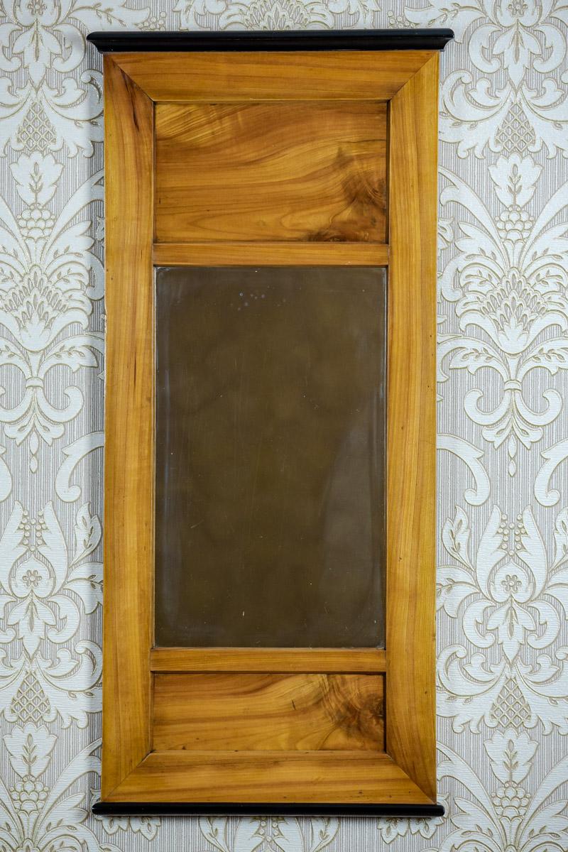 We present you a medium-sized mirror in a simple, rectangular Biedermeier frame.
This item is from the first half of the 19th century.
The light veneer contrasts with the black cornices.

The frame is after renovation and finished with French
