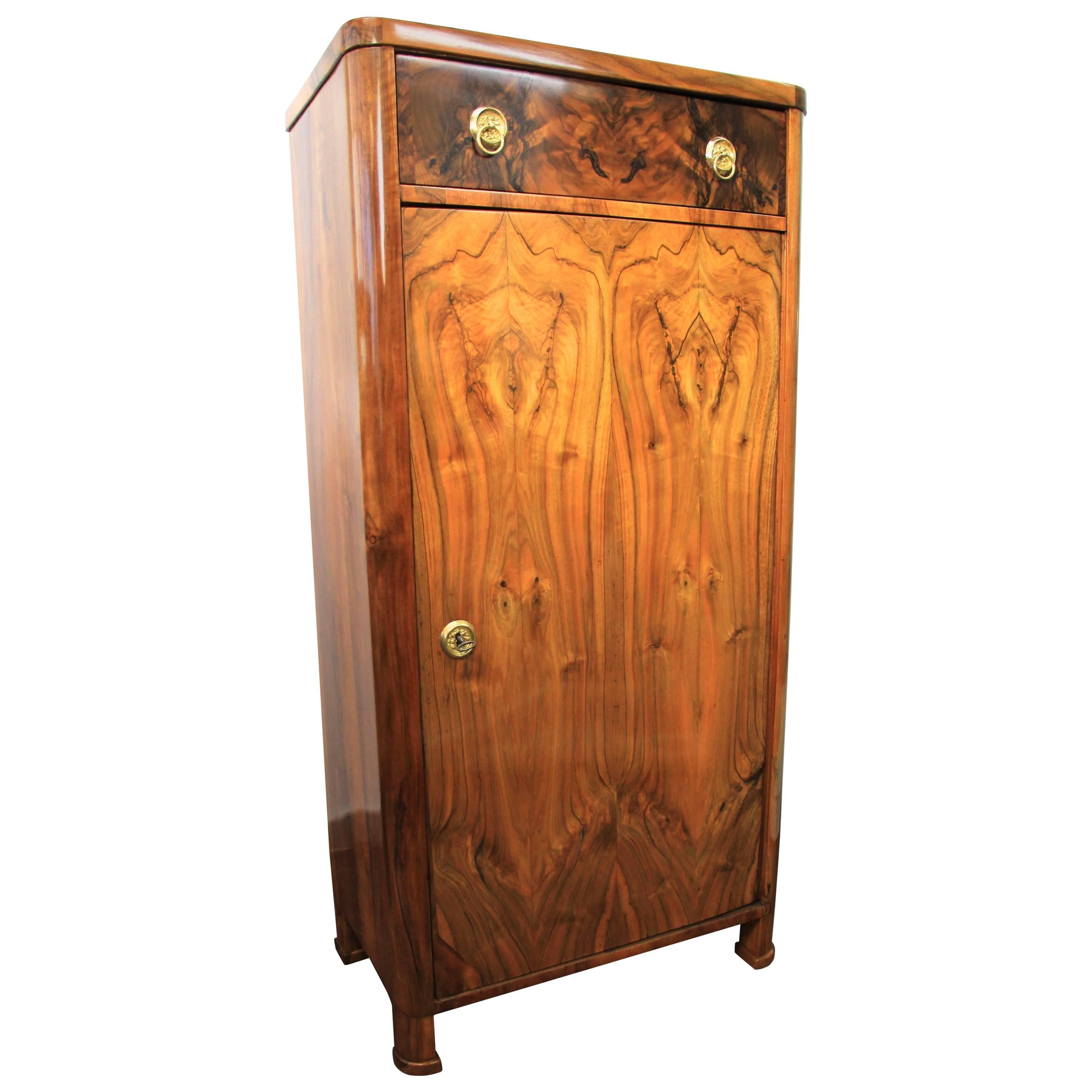 Great looking 19th century Biedermeier nut wood cabinet with drawer from the late second period in Austria, circa 1880. Adorned by a beautifully mirror matched nutwood/ burl veneer work, this antique cabinet shows an impressive veneered front