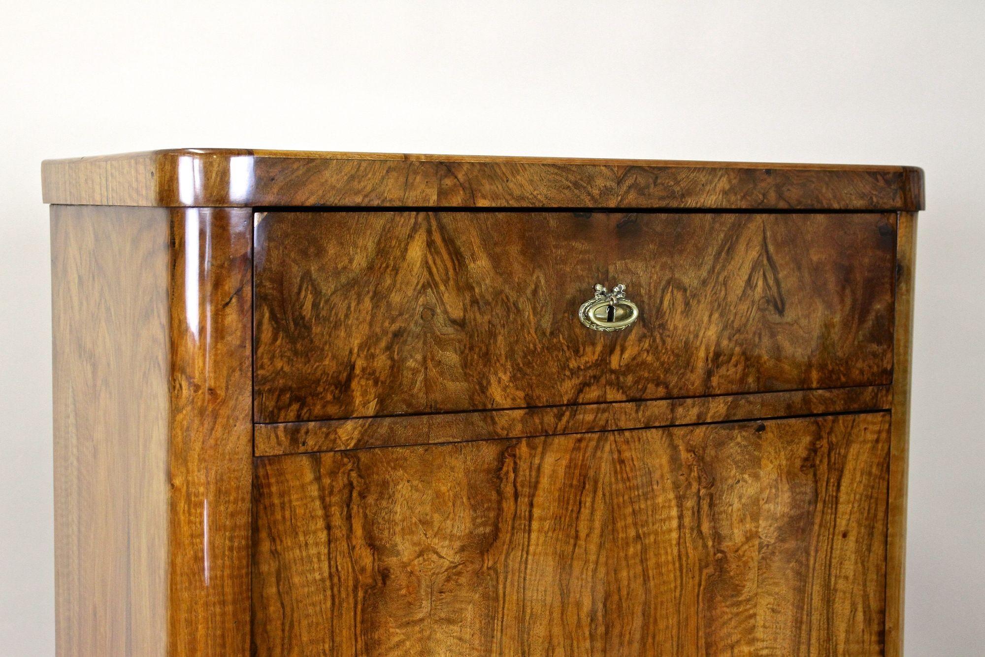 Charmante armoire Biedermeier en bois de noyer du 19e siècle, de la célèbre période autrichienne autour de 1850. Ornée d'un superbe placage de bois de noyer assorti à un miroir, cette armoire ancienne est dotée d'une grande porte verrouillable