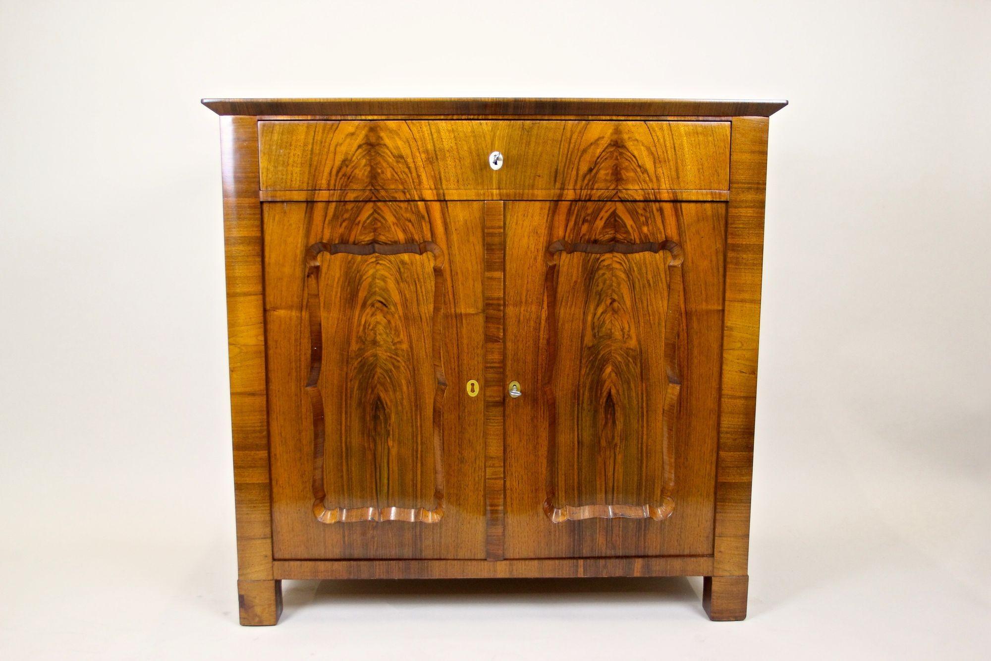 Notevole commode in legno di noce del XIX secolo, realizzata ad arte nella famosa epoca Biedermeier in Austria intorno al 1845. Questo comò di forma compatta, chiamato anche 