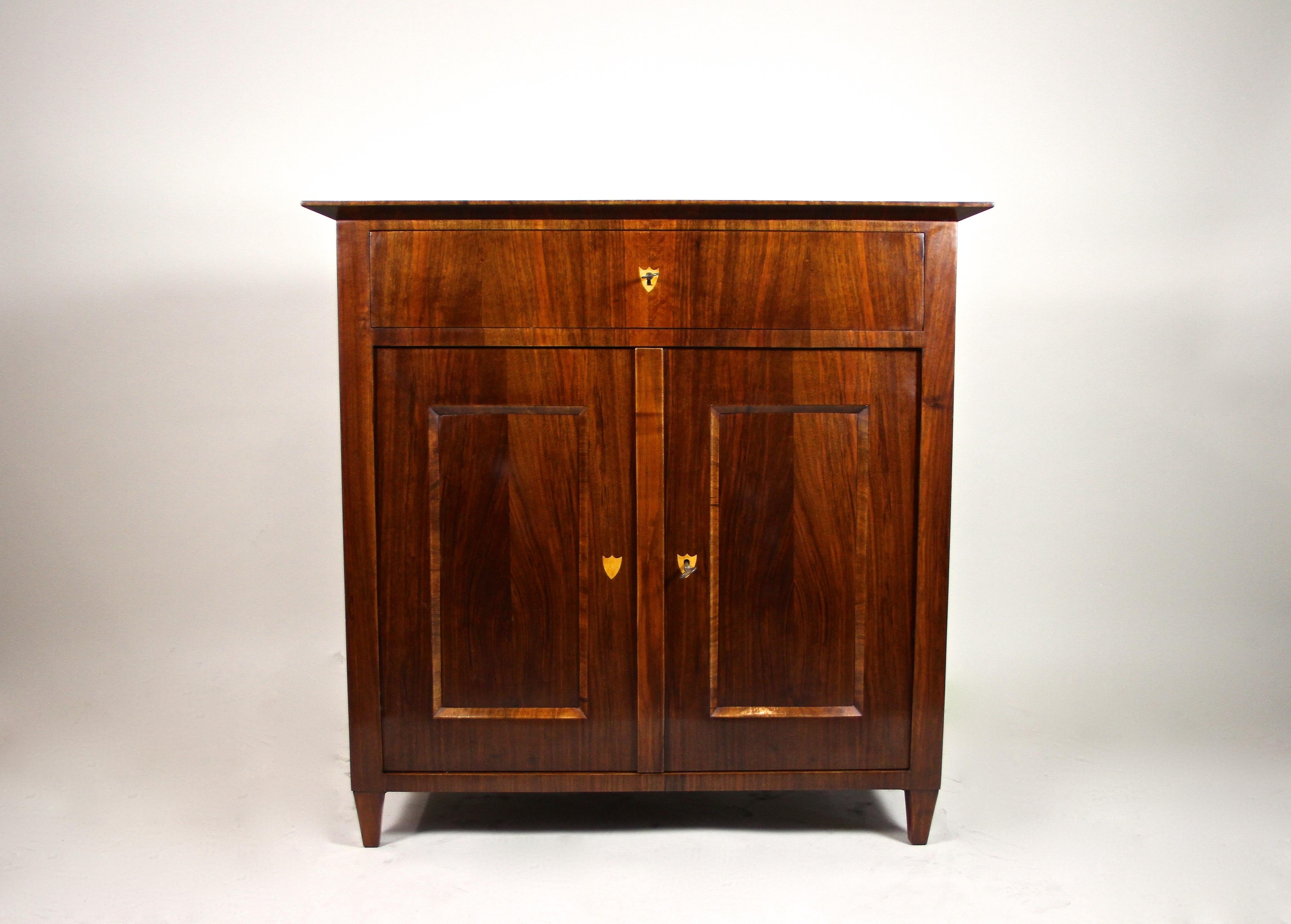 Fantastic Biedermeier nutwood trumeau commode from the second period in Austria around 1860. This compact Biedermeier commode shows a fine nutwood veneer work with beautiful grain, radiantly hand-polished with ruby shellac. This outstanding Trumeau