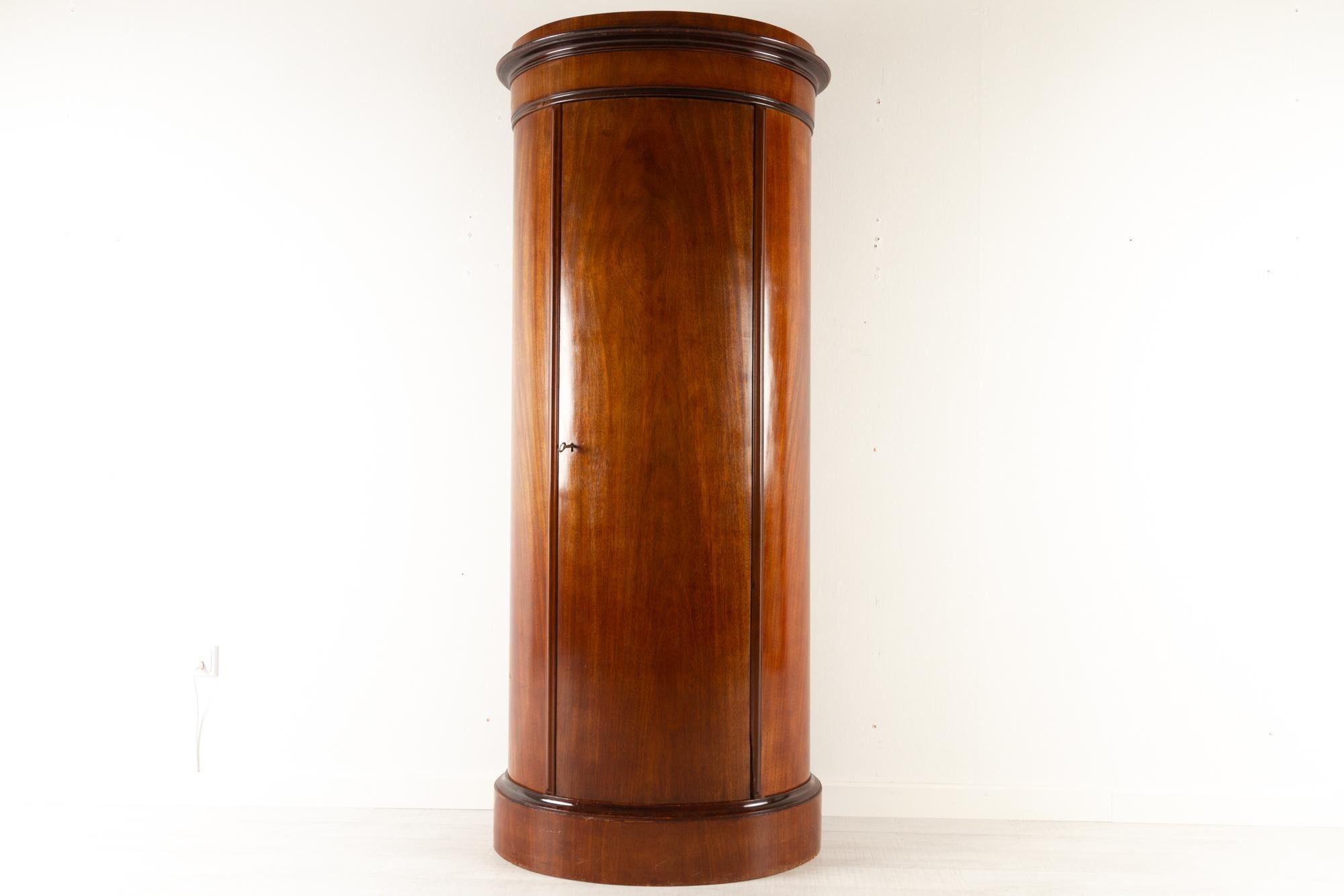 19th Century Biedermeier pedestal cabinet 1850s
Tall Danish oval cabinet from the Biedermeier/late empire period. Four fixed oak shelves behind the curved door. Door has a lock and key. Serves a dual purpose, both a cabinet and a pedestal for