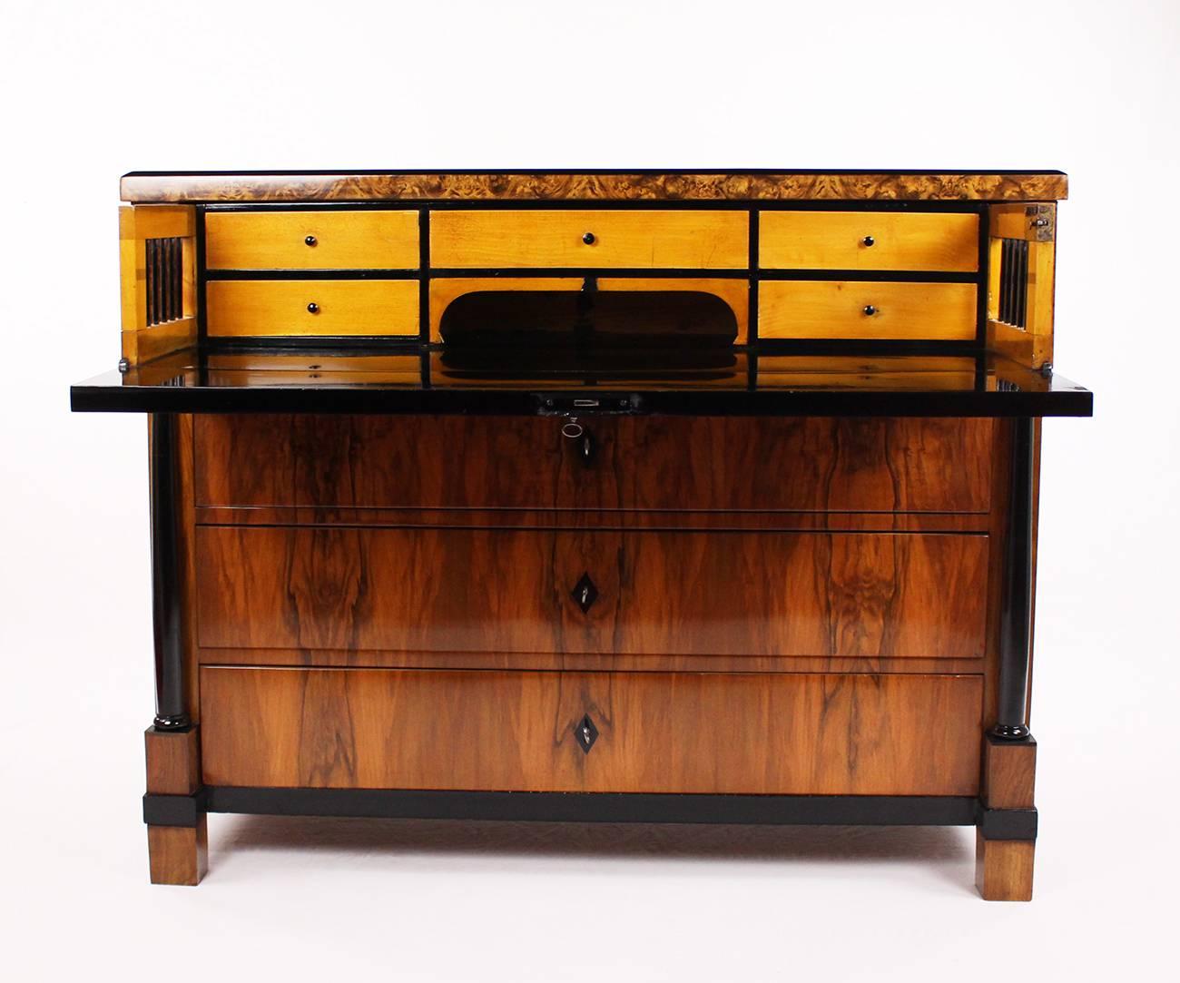 • 19th century Biedermeier period-writing chest of drawers, circa 1830-1840
• Walnut-tree and nut root wood veneered
• Partly ebonized
• Four large pushes, the upper push as a writing surface extendable
• Nice reflected veneer
• Restored