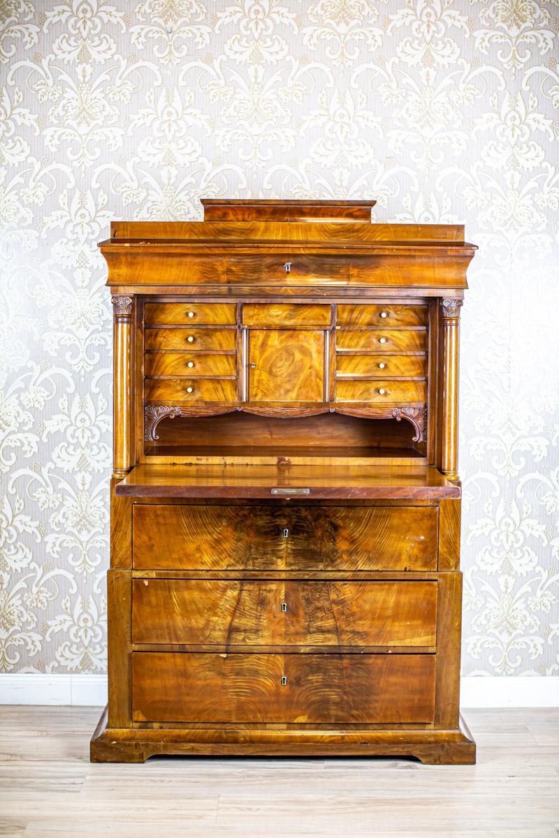 19th Century Biedermeier Secretary Desk in Light Brown Veneered with Walnut

We present you this secretary desk from the second half of the 19th century veneered with walnut.
The corpus is composed of a base with two drawers placed on slightly