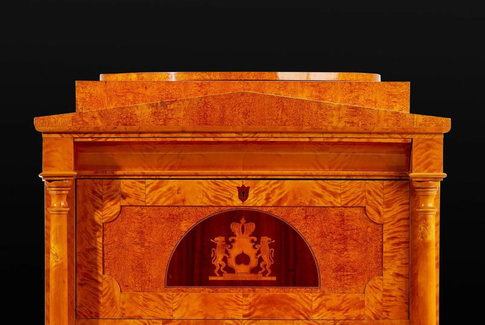Una raffinata scrivania Biedermeier del XIX secolo, squisitamente realizzata in radica di acero e impiallacciature, che mostra l'eleganza e la semplicità tipiche del periodo Biedermeier. Il design a ribalta rivela un interno splendidamente arredato