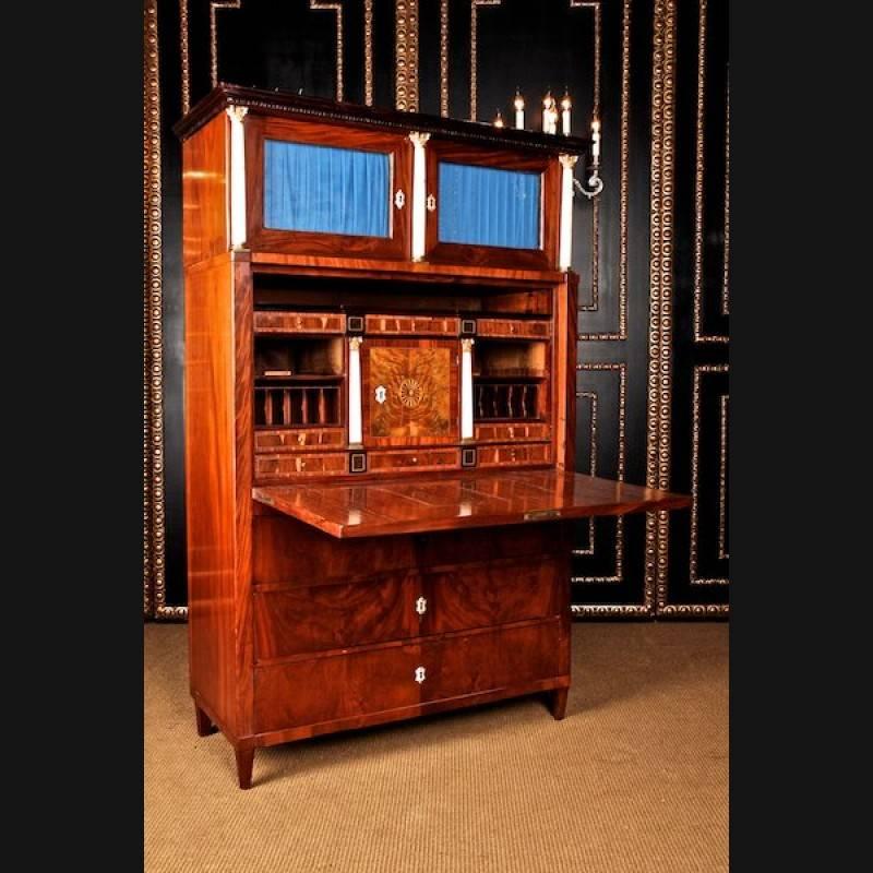 Segretaria classicista, circa 1800-1810.
Cuba in mogano su legno massiccio di conifera parzialmente ebanizzato. Corpo alto a destra, dal design architettonico, su gambe coniche. Nella parte anteriore tre cassetti. Lavagna dritta, dietro di essa