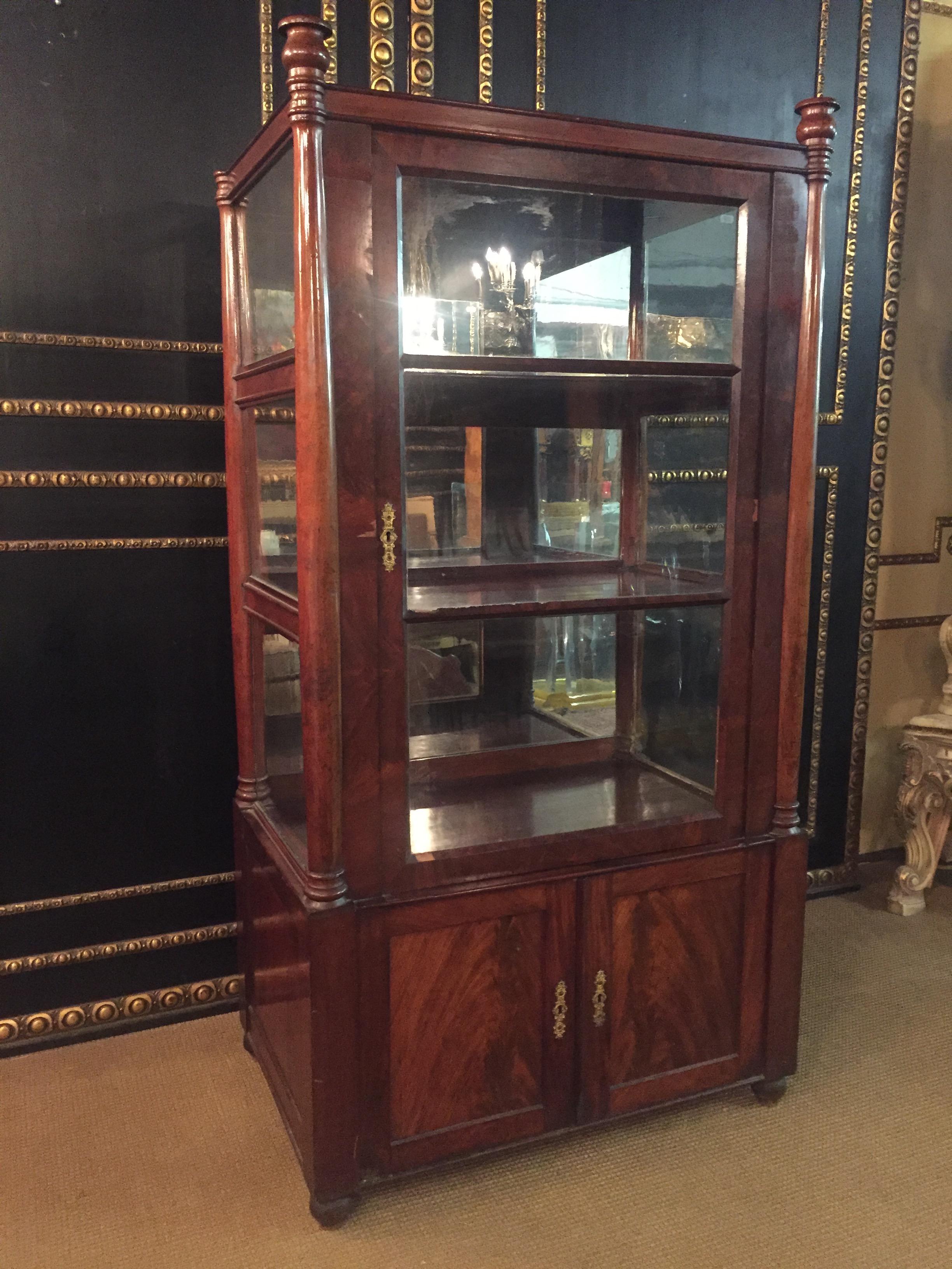 Three-sided glazed glass vitrine circa 1825 in the sense of Karl Friedrich Schinkel. High-quality Mahogany on solid softwood. Recessed frame box. Architecturally arranged front with flanking columns, Three-sided sprout-glazed corpus. Stepped
