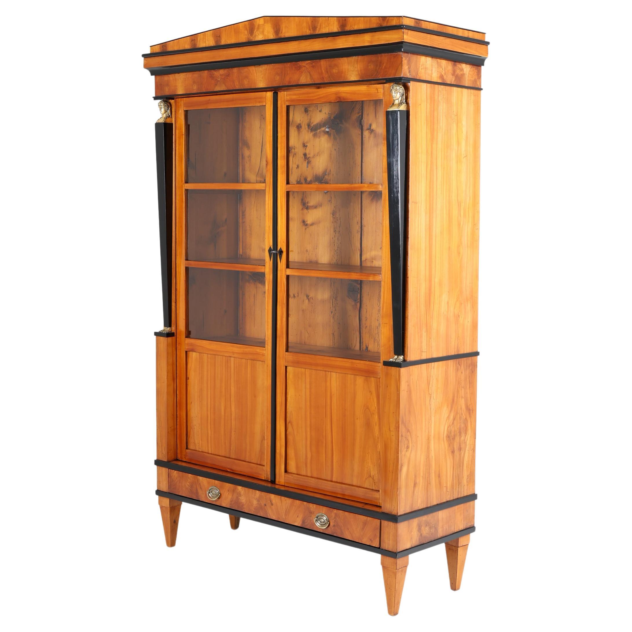 Vitrina Biedermeier de principios del siglo XIX
Sur de Alemania, 1820-1825

Vitrina Biedermeier de pie sobre patas cónicas con dos puertas. Cada puerta con cuatro campos, tres de ellos con cristal. Esta vitrina antigua está chapada en madera de