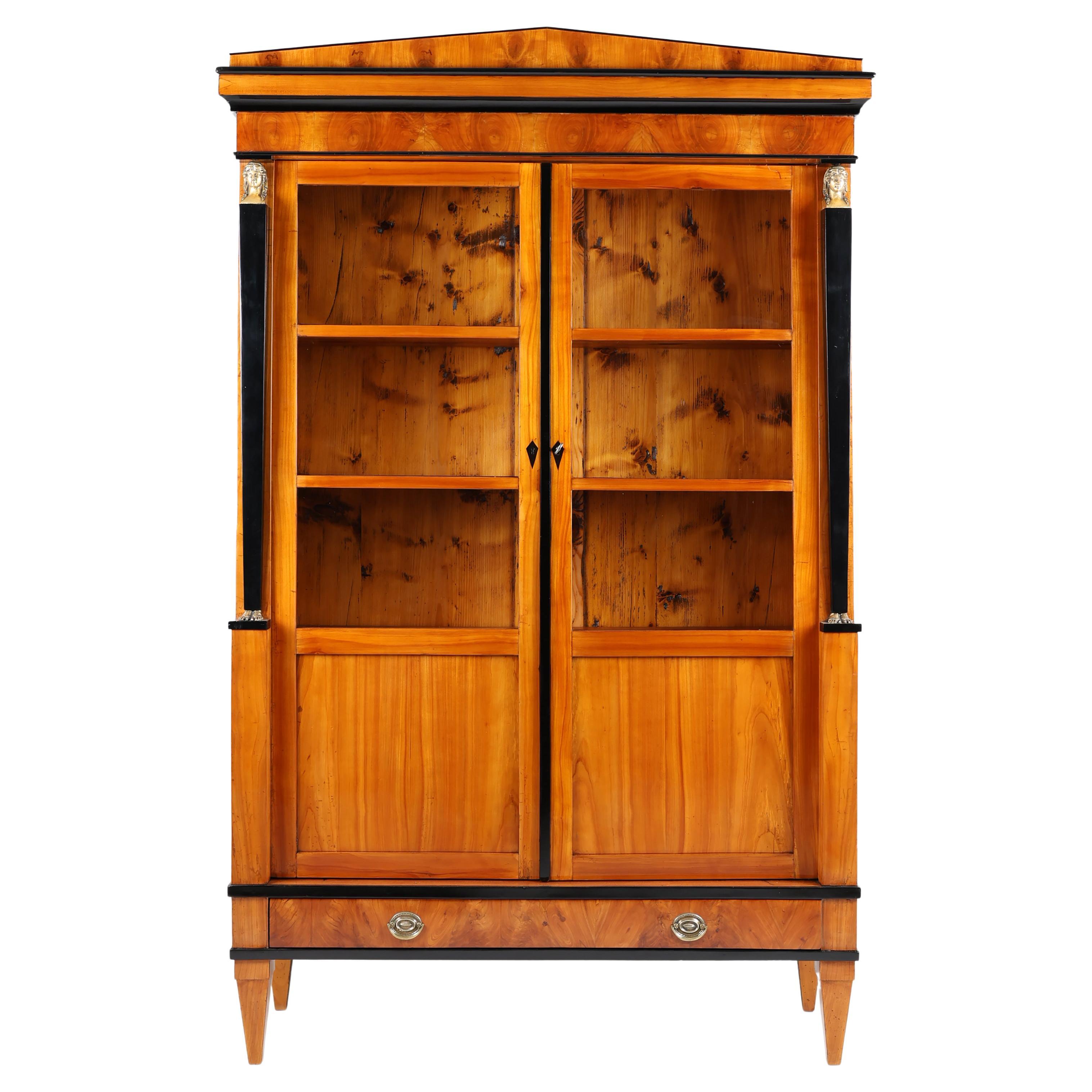 Early 19th Century Biedermeier Vitrine
South Germany, 1820-1825

Standing on conical feet Biedermeier Vitrine with two doors. Each door with four fields, three of them with glass. This antique Vitrine is veneered with cherry wood with very nice