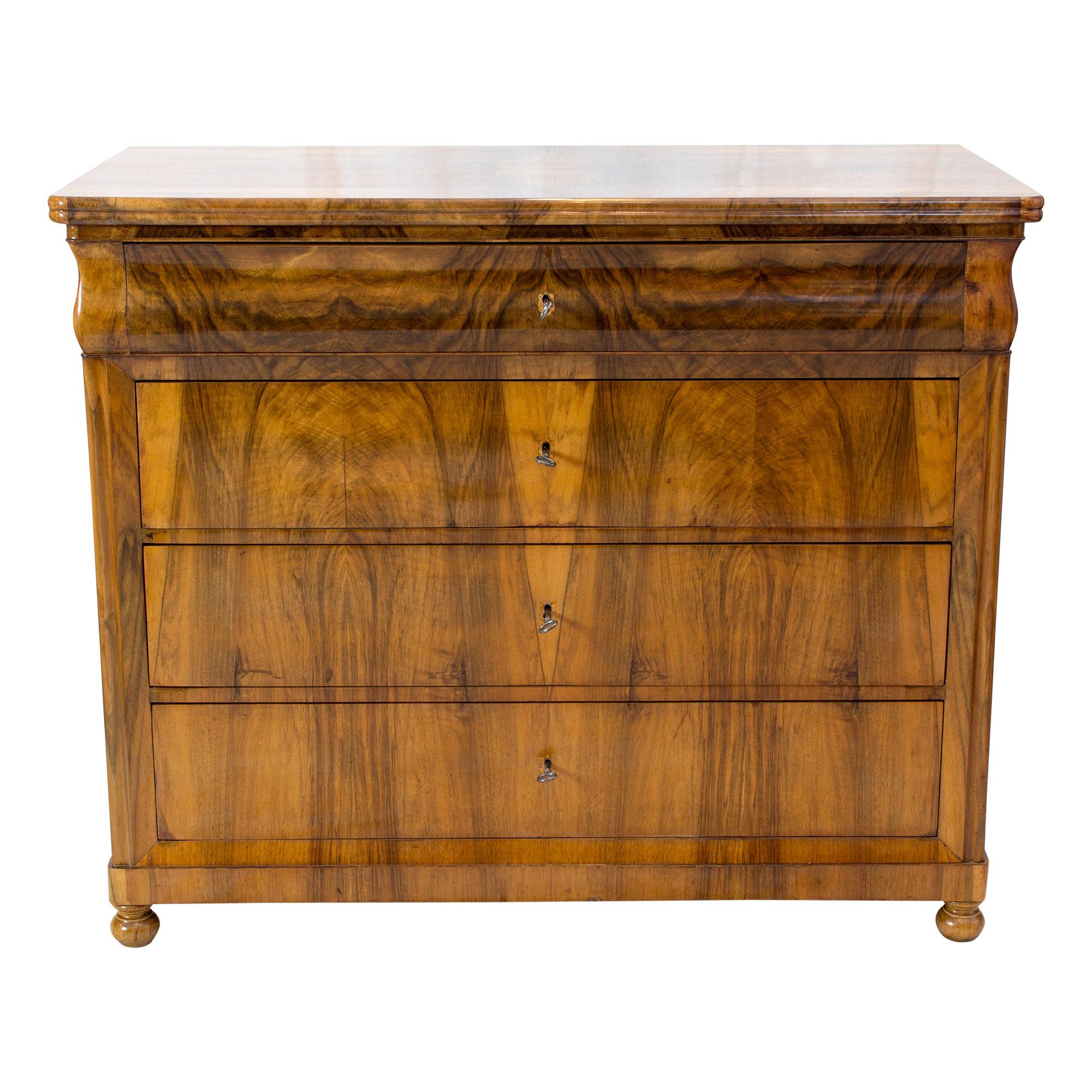 The chest of drawers dates from the Biedermeier period. The chest of drawers has a beautiful walnut veneer picture, which covers a spruce wood body. In very good restored hand polished condition.