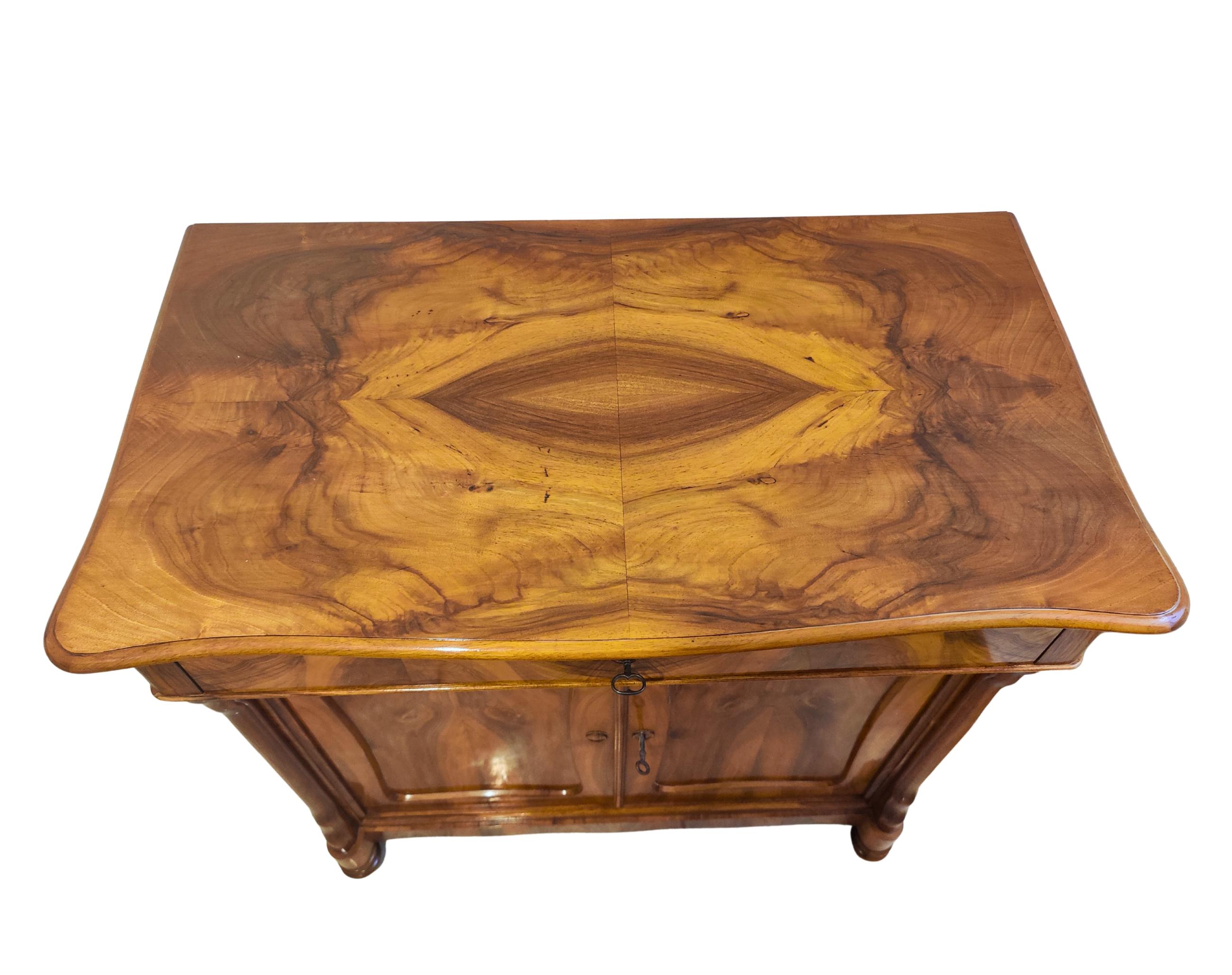 Bellissimo mezzo mobile Biedermeier dell'epoca del tardo Biedermeier / Louis Philippe, intorno al 1845. Il mobile è rivestito con una bellissima impiallacciatura di noce su un corpo in abete rosso.
In alto c'è un cassetto, in basso ci sono due