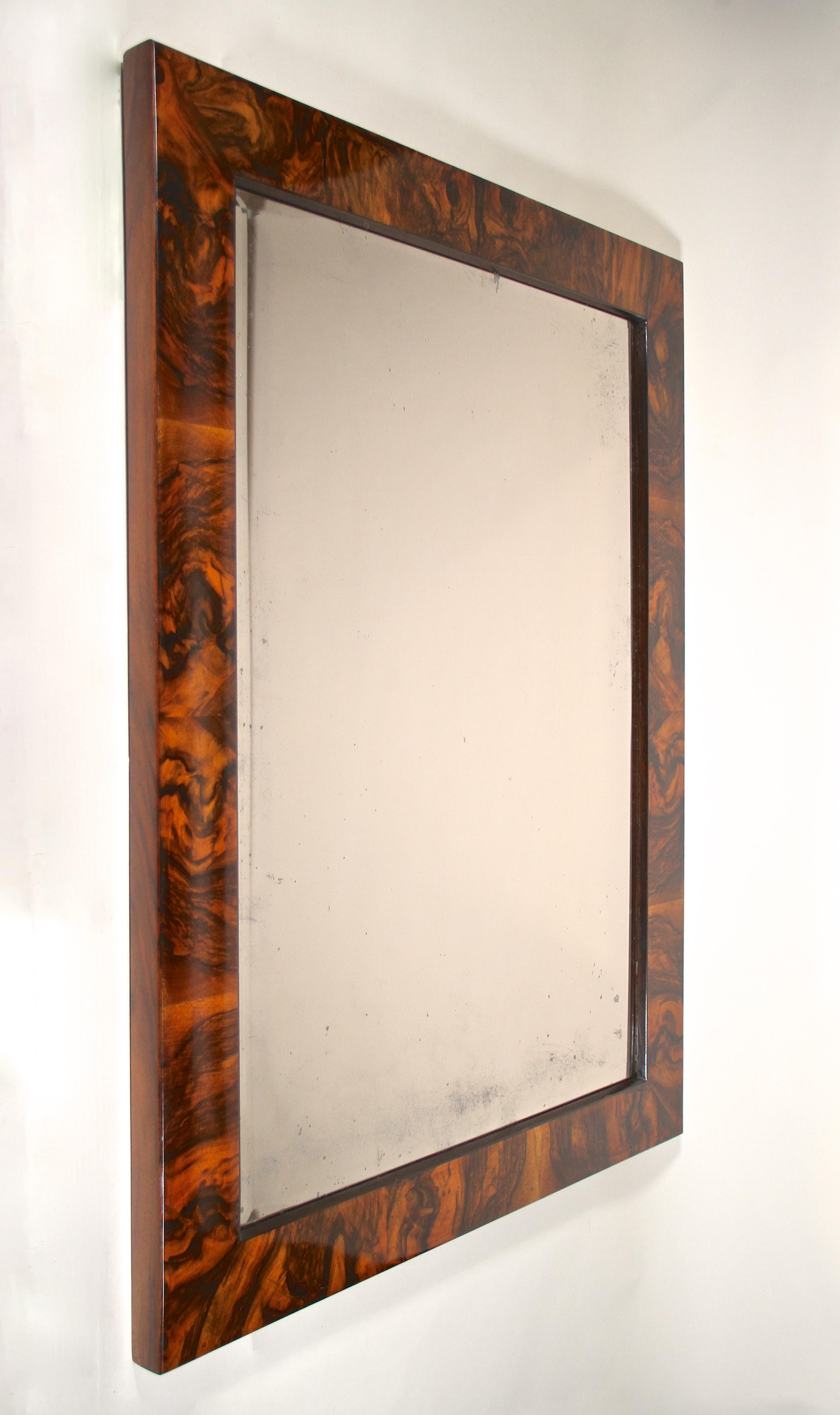 Magnificent 19th century burr walnut wall mirror from the famous Biedermeier era in Vienna/ Austria around 1820. This amazing wall mirror from the early period comes with a traditional overlapped substructure made of spruce wood and impresses with a