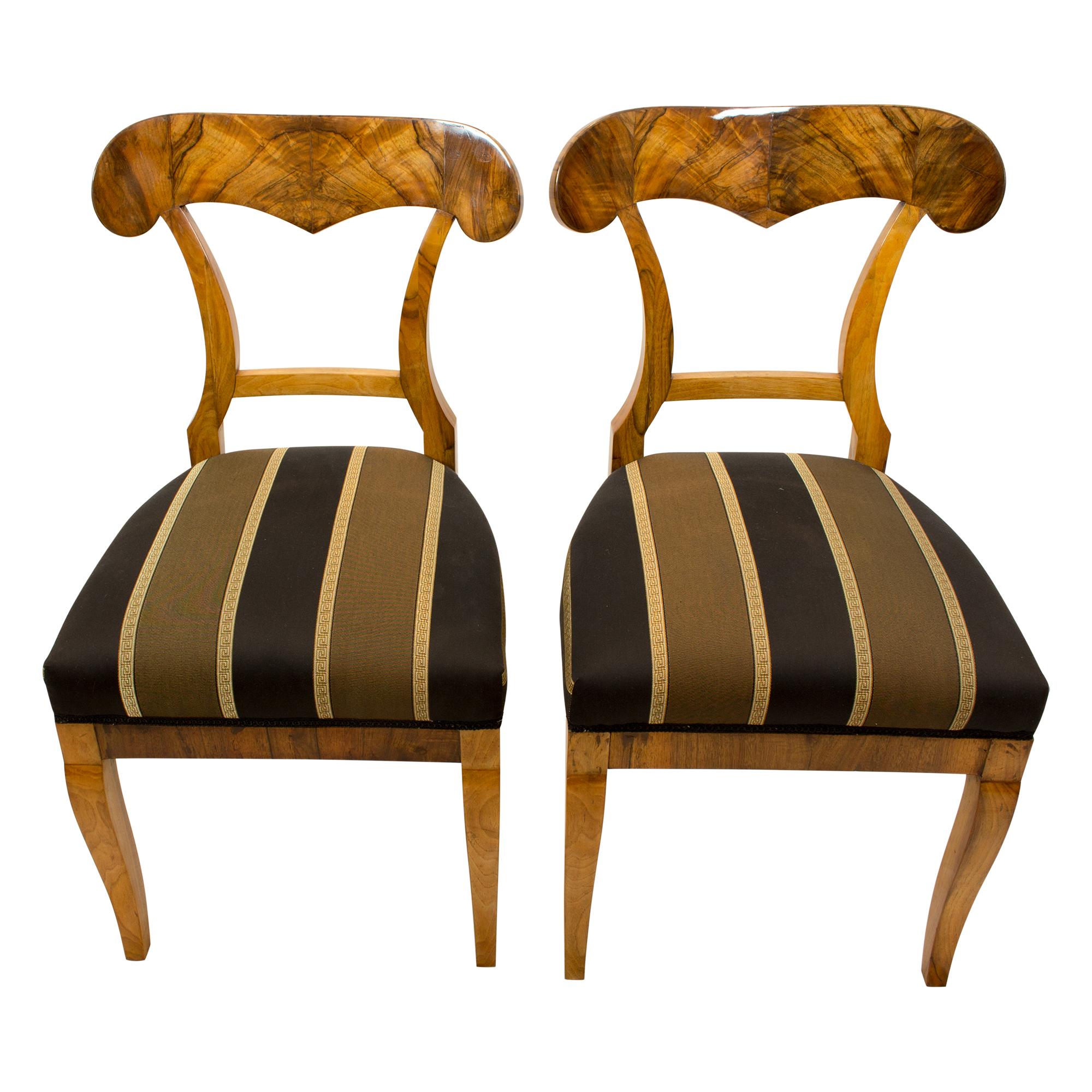 Schönes Paar Biedermeier Schaufelstühle, hergestellt um 1825 mit dickem Nussbaum und Nussbaumfurnier auf Fichtenholz. Der Stuhl wurde im traditionellen Stil mit Riemen und Federn neu gepolstert und mit neuem Stoff bezogen. In sehr gutem