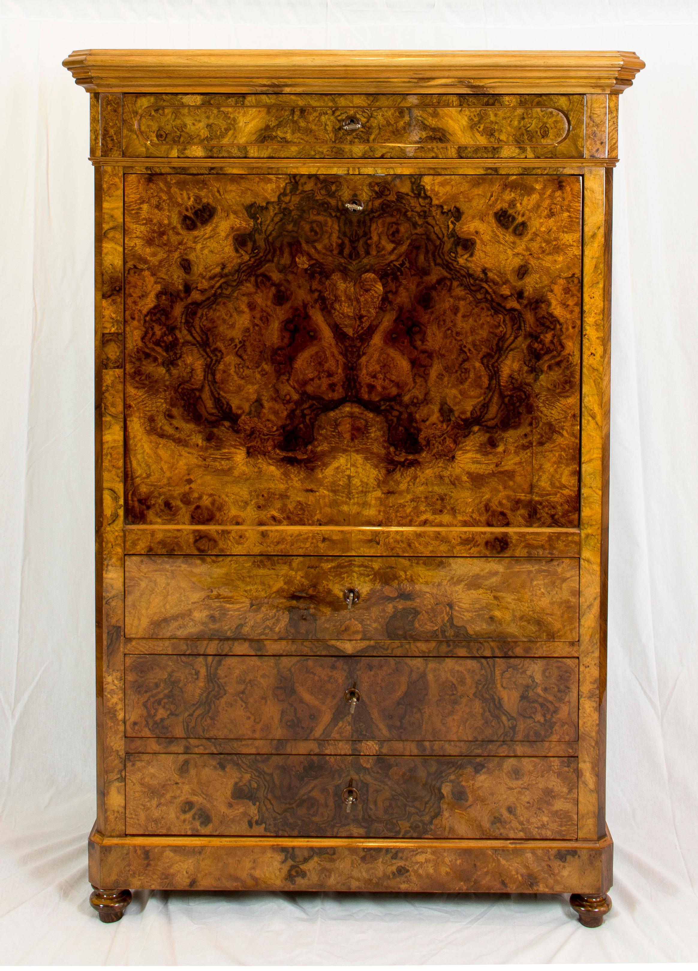 Bellissimo piccolo secretaire  dell'epoca del tardo Biedermeier, circa 1840. Il Secretaire è rivestito all'esterno con impiallacciatura in noce e noce radica su un corpo in pino. La parte interna è rivestita con una bellissima impiallacciatura di