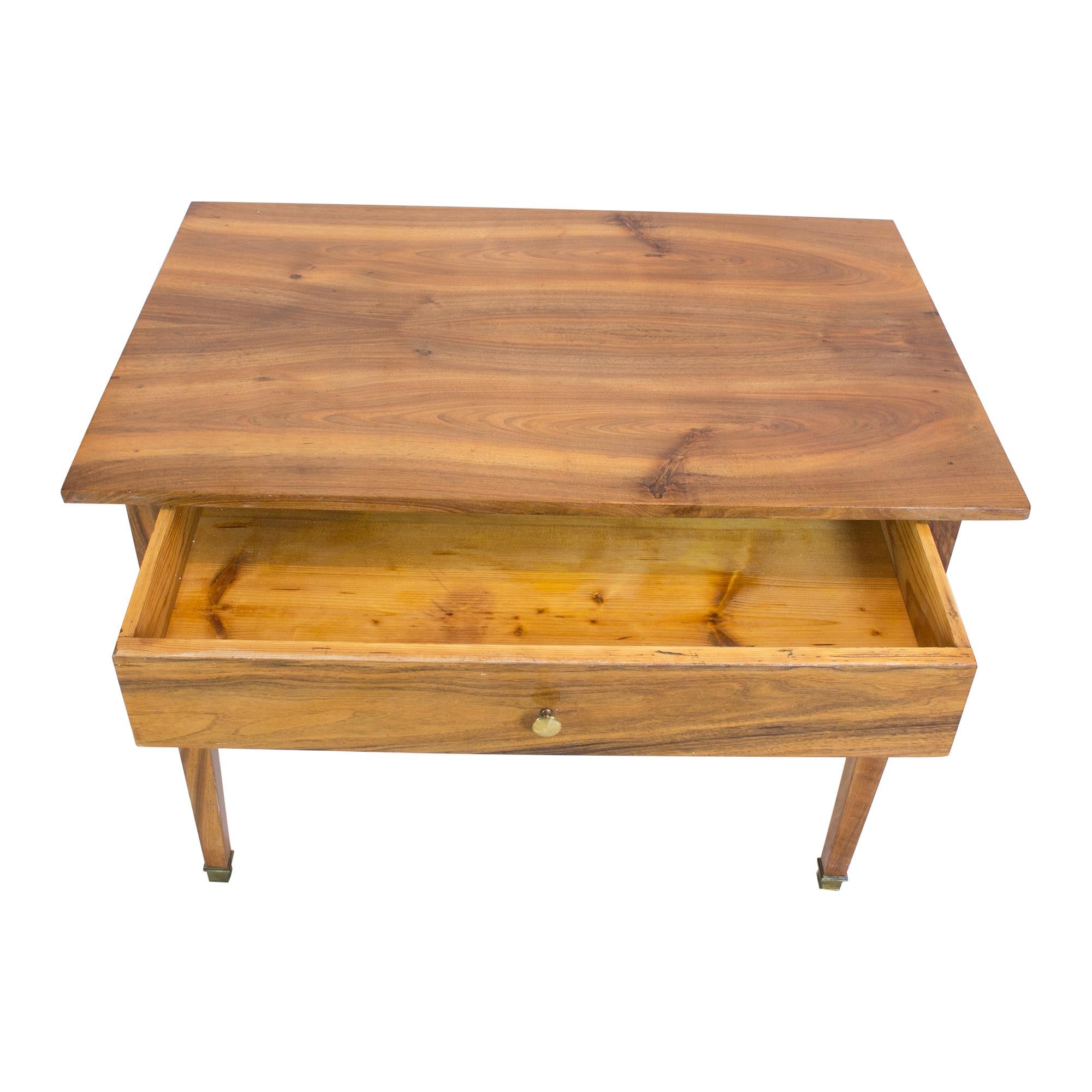 Der Beistelltisch ist aus massivem und furniertem Nussbaumholz gefertigt, die Tischbeine und die Platte sind aus massivem Nussbaumholz. Ein wunderschönes, zeitloses Design aus der Zeit des Biedermeier um 1825. Die Schublade ist, wie üblich, aus