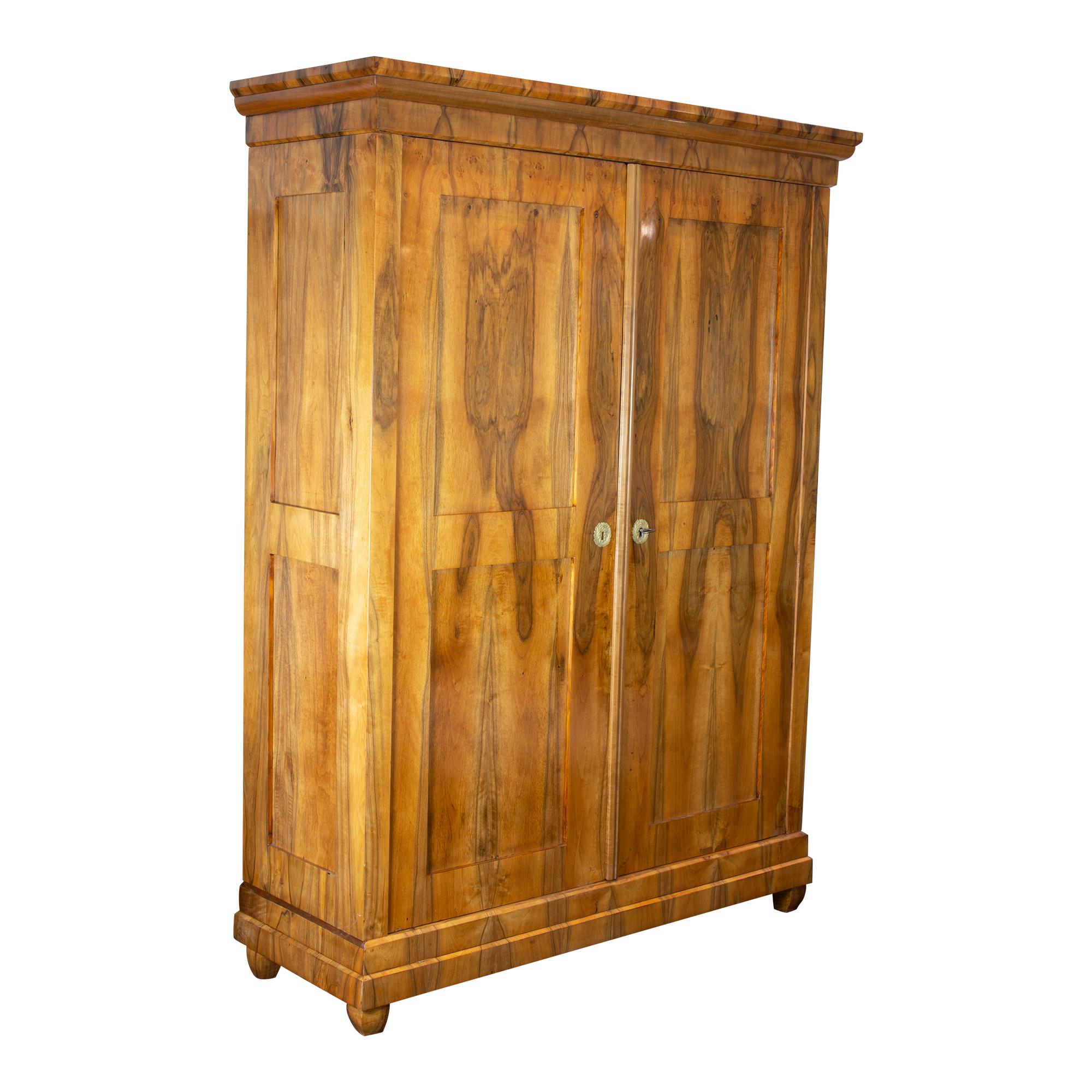 This exquisite Biedermeier wardrobe is a true gem, showcasing the timeless beauty and elegance of a bygone era. Crafted from high-quality walnut veneer on a softwood body, this wardrobe is both durable and stylish. With its sleek and straightforward