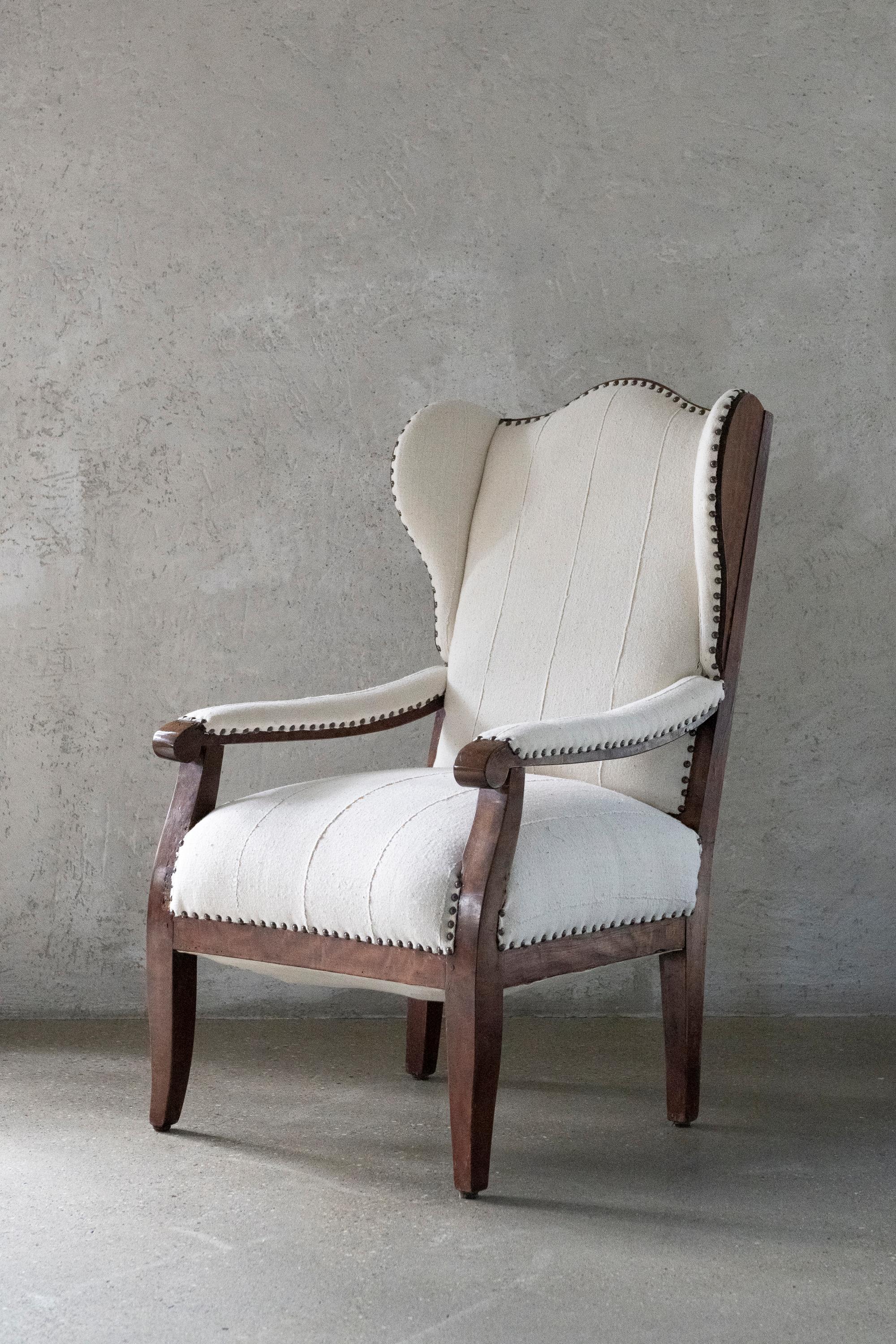 Elegant 19th century Biedermeier-style armchair crafted from richly figured burl wood. The graceful lines and sculpted arms exemplify the refined simplicity of the Biedermeier period, while the wingback form adds a sense of comfort and presence.
