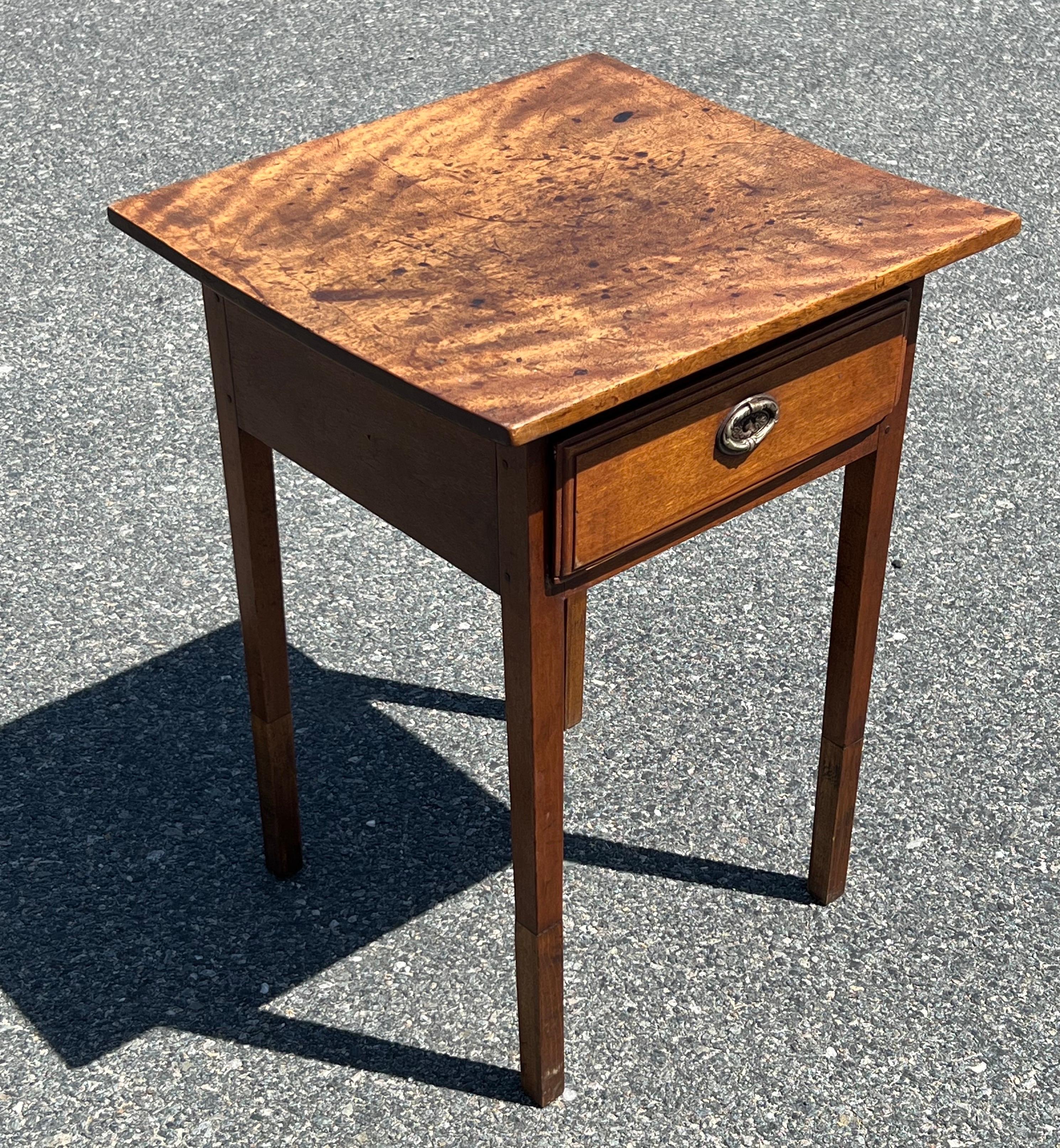 Diminutive 19th century Birch side and/or sewing table with single drawer with stepped drawer face and oval embossed brass pull. On two part tapered legs. Slightly bowed top and old break at bottom right of drawer.