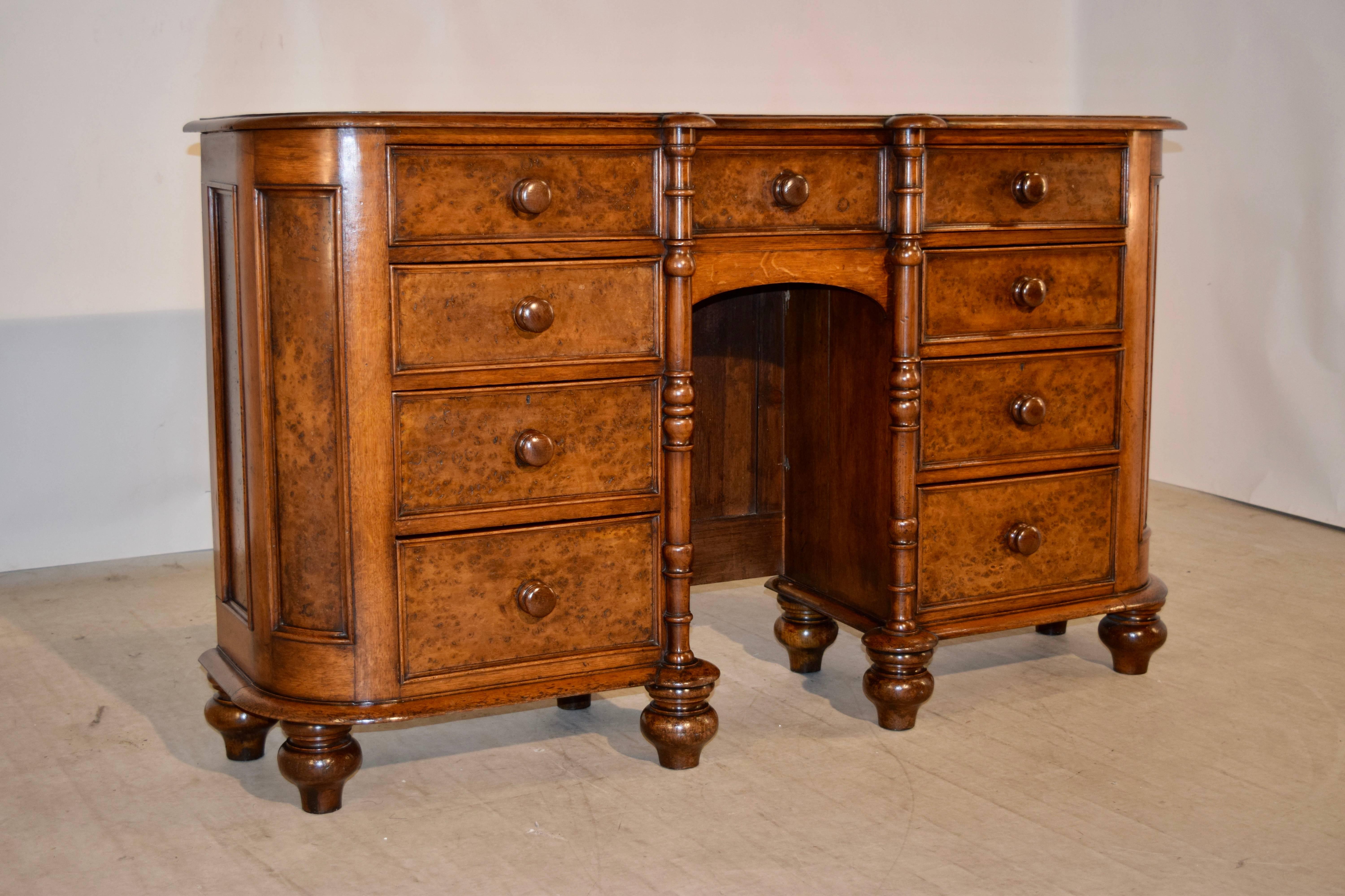 19th century English sideboard made from bird's-eye maple and oak. The top is beveled around the edge and follows down to the case, which contains a wide single drawer with three draw fronts, over two banks of three drawers each. These are flanking