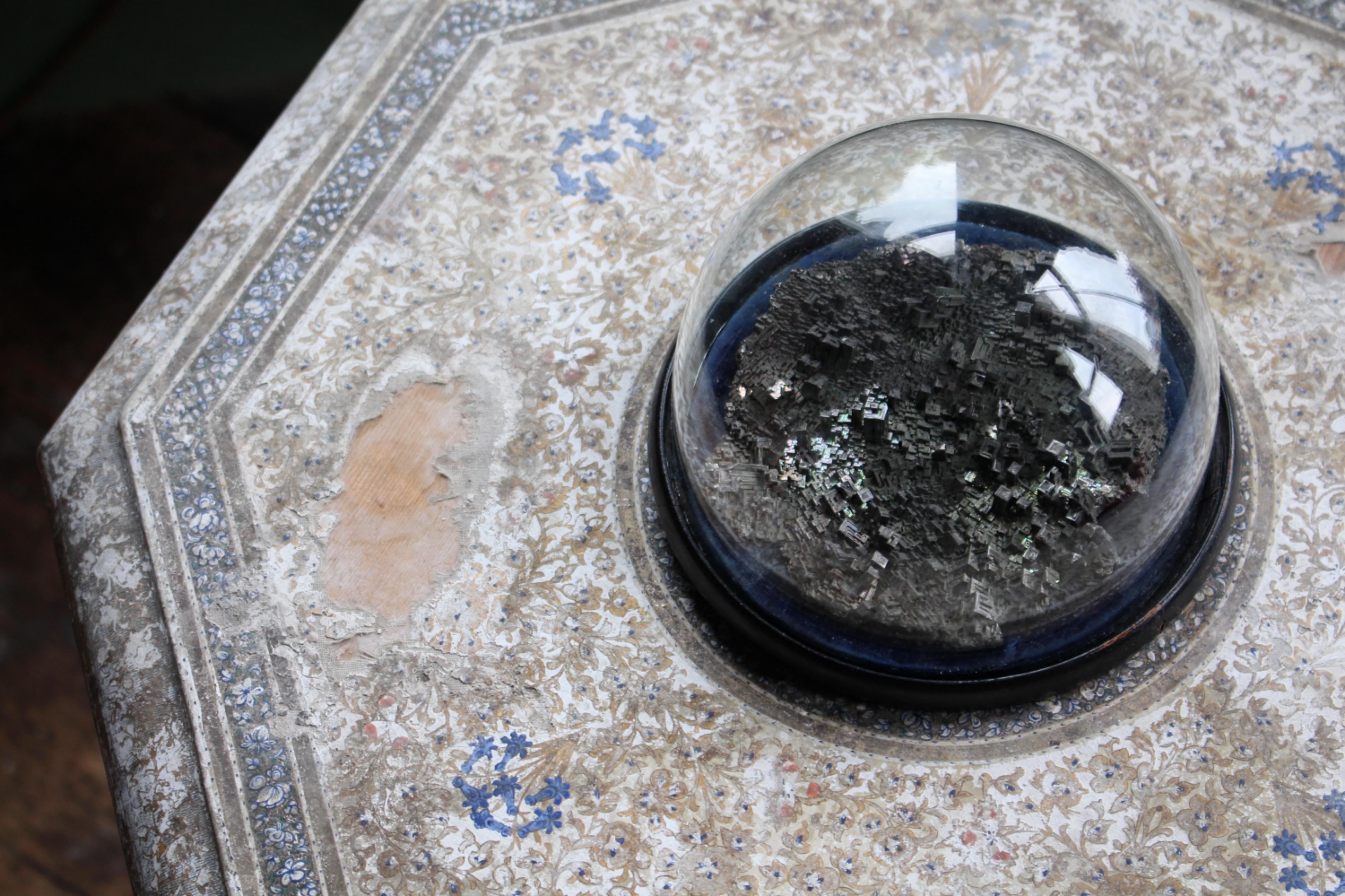 Un spécimen de bismuthinite en argent lustré, logé dans sa bulle d'exposition en verre d'origine et en ébène tourné. 

Le bismuth, également connu sous le nom de 