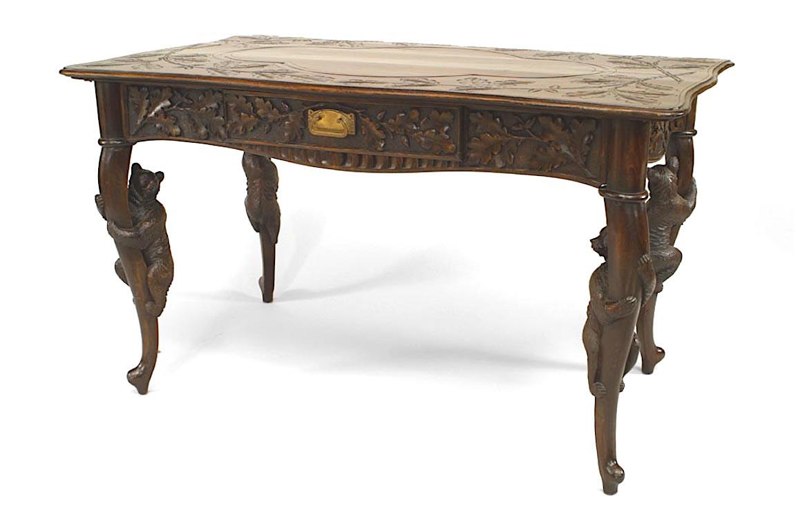 Rustic Black Forest (19th Century) bear carved walnut table desk with leaf and floral carving and single drawer.
 