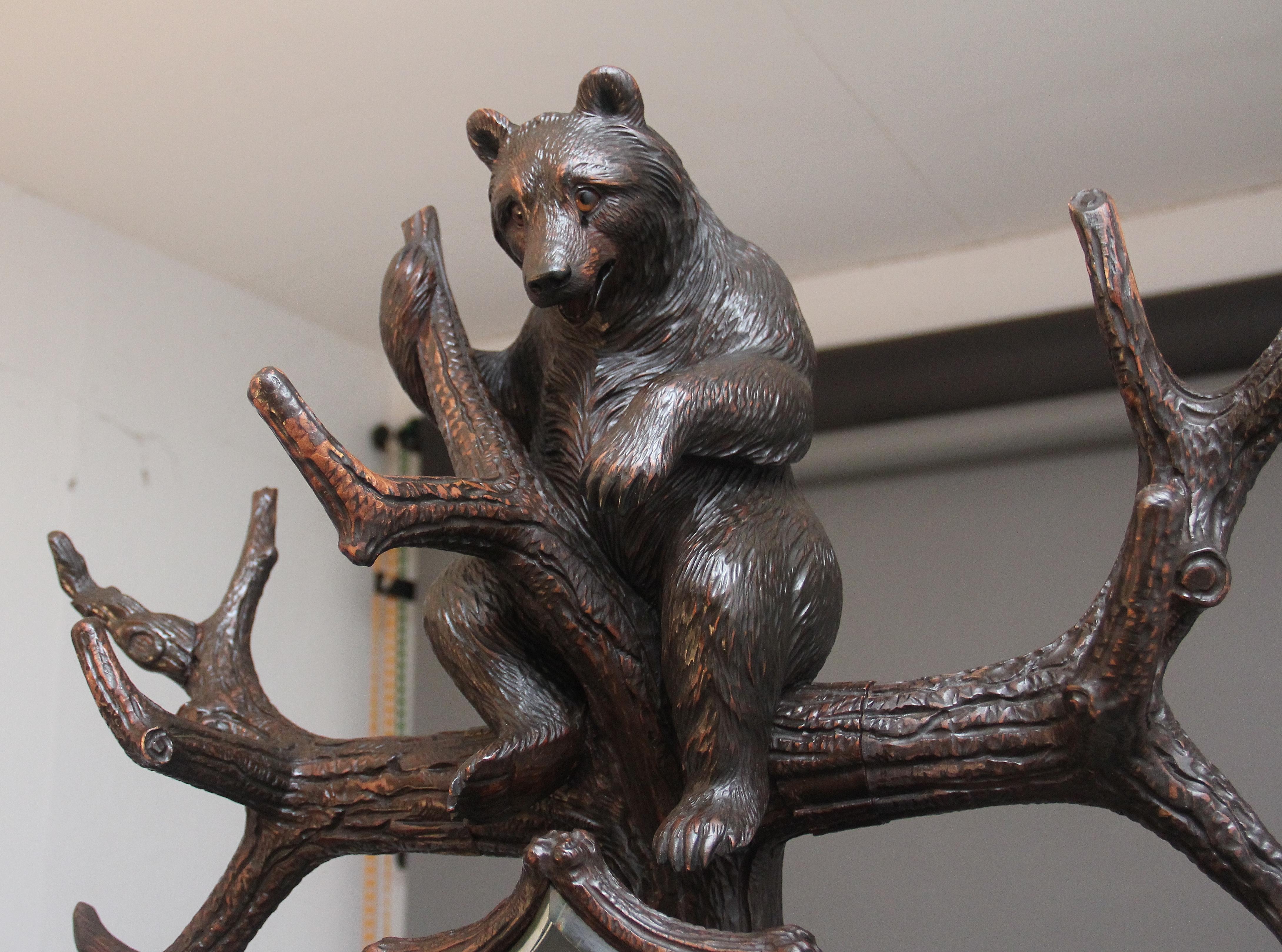 Un porta orso in legno di tiglio della Foresta Nera del XIX secolo, di qualità superba e finemente intagliato, con un cucciolo che gioca tra i rami in alto, l'orso in basso con gli occhi di vetro che guardano verso il suo cucciolo e tre specchi