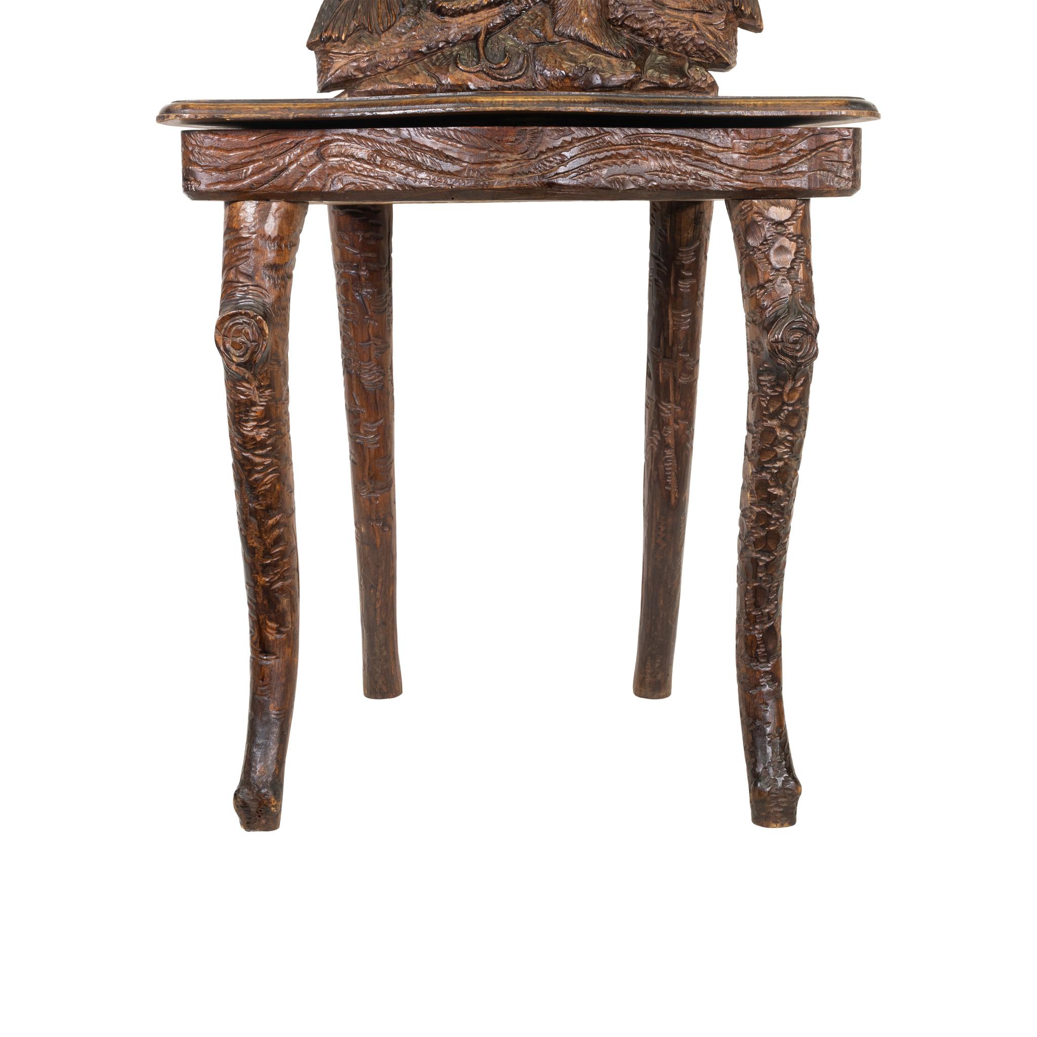 Black Forest Swiss carved chair having bear on fallen log. Carved bear on lifting seat which once had a music box. Part of the Brienz collection plate 26.

Origin: Swiss
Period: Last quarter of the 19th century
Dimensions: 38