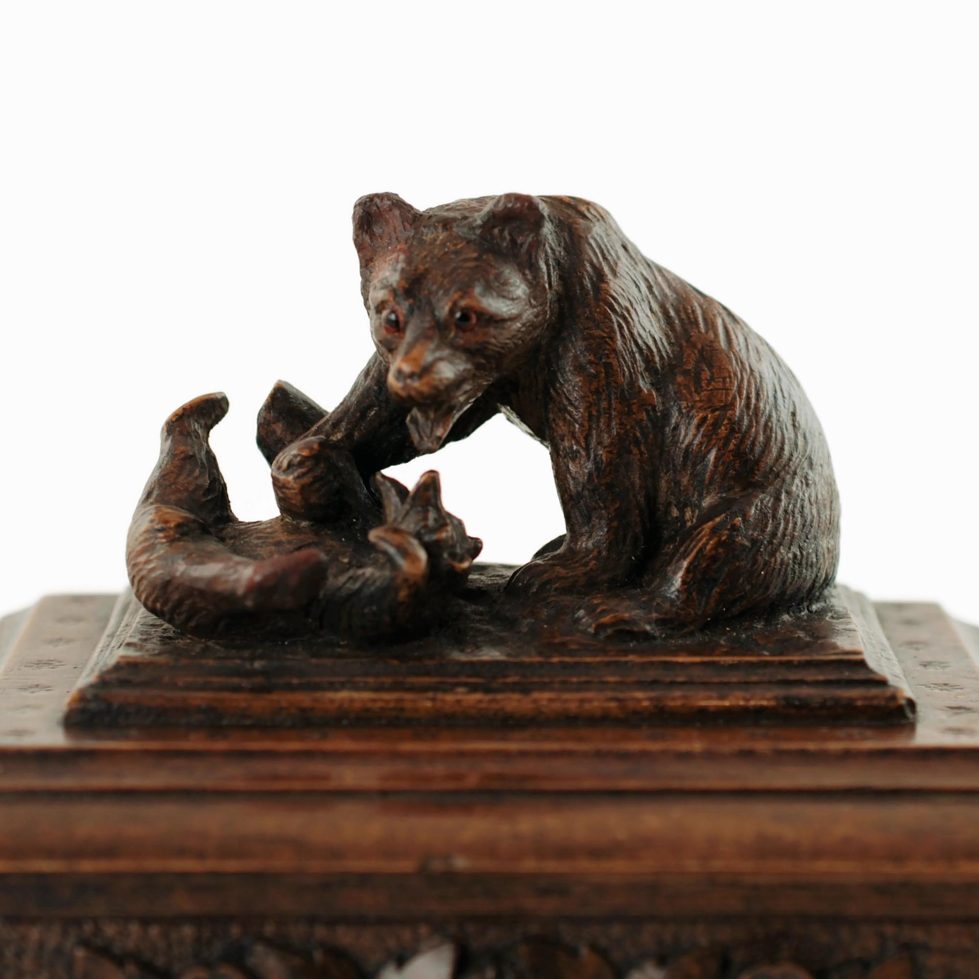This unusual antique Black Forest box features a pair of fully dimensional bears cavorting at the base of a tree stump. The mother and cub have been finished with a high level of detail including glass eyes in the larger bear's head. The bears are