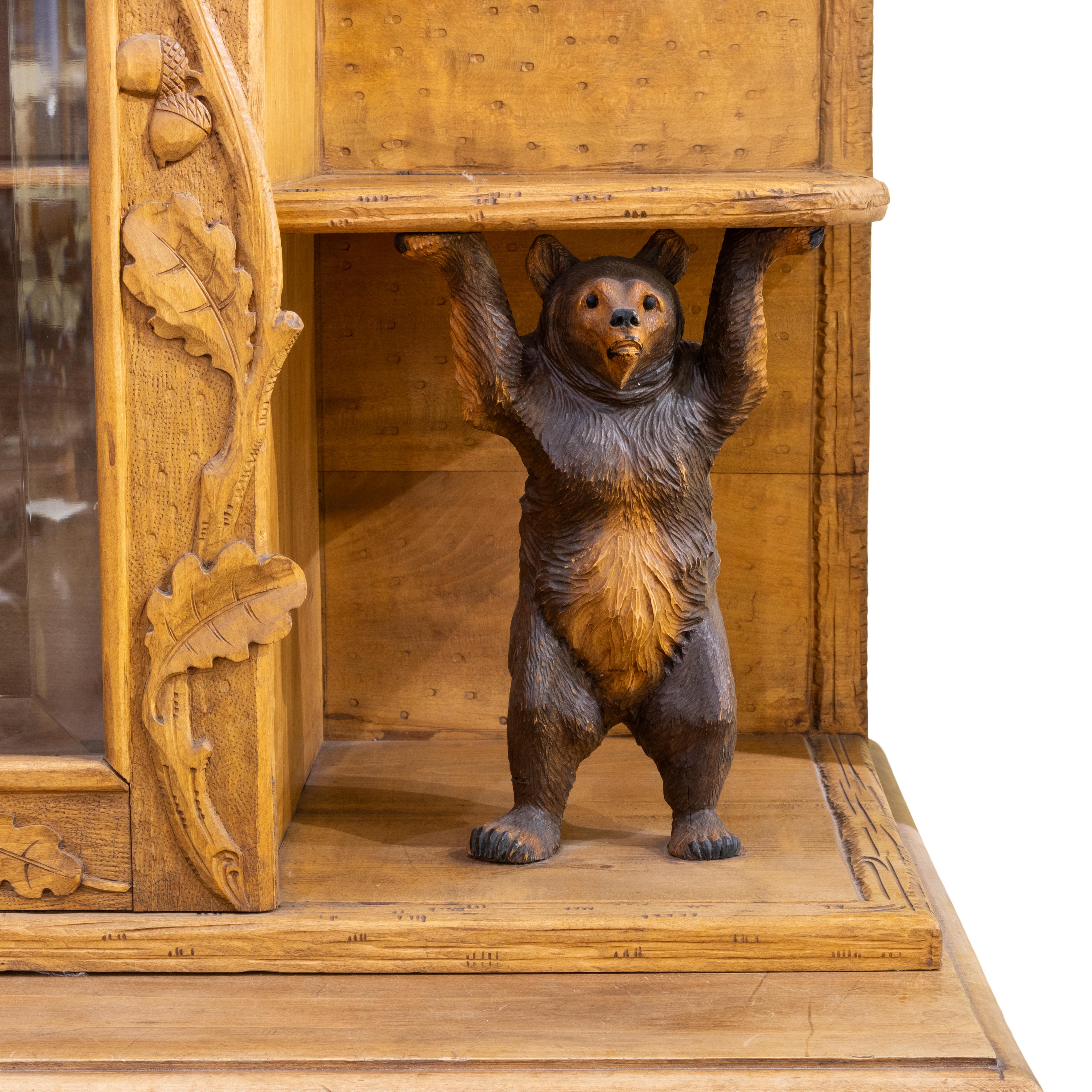 Swiss carved china cabinet. Front door has bear paying accordion. Mother and father dancing together as cub plays close by. Two bears supporting shelves. Two drawers for flatware. Beveled glass door on top. Pictured in Black Forest Bears Plate 12.