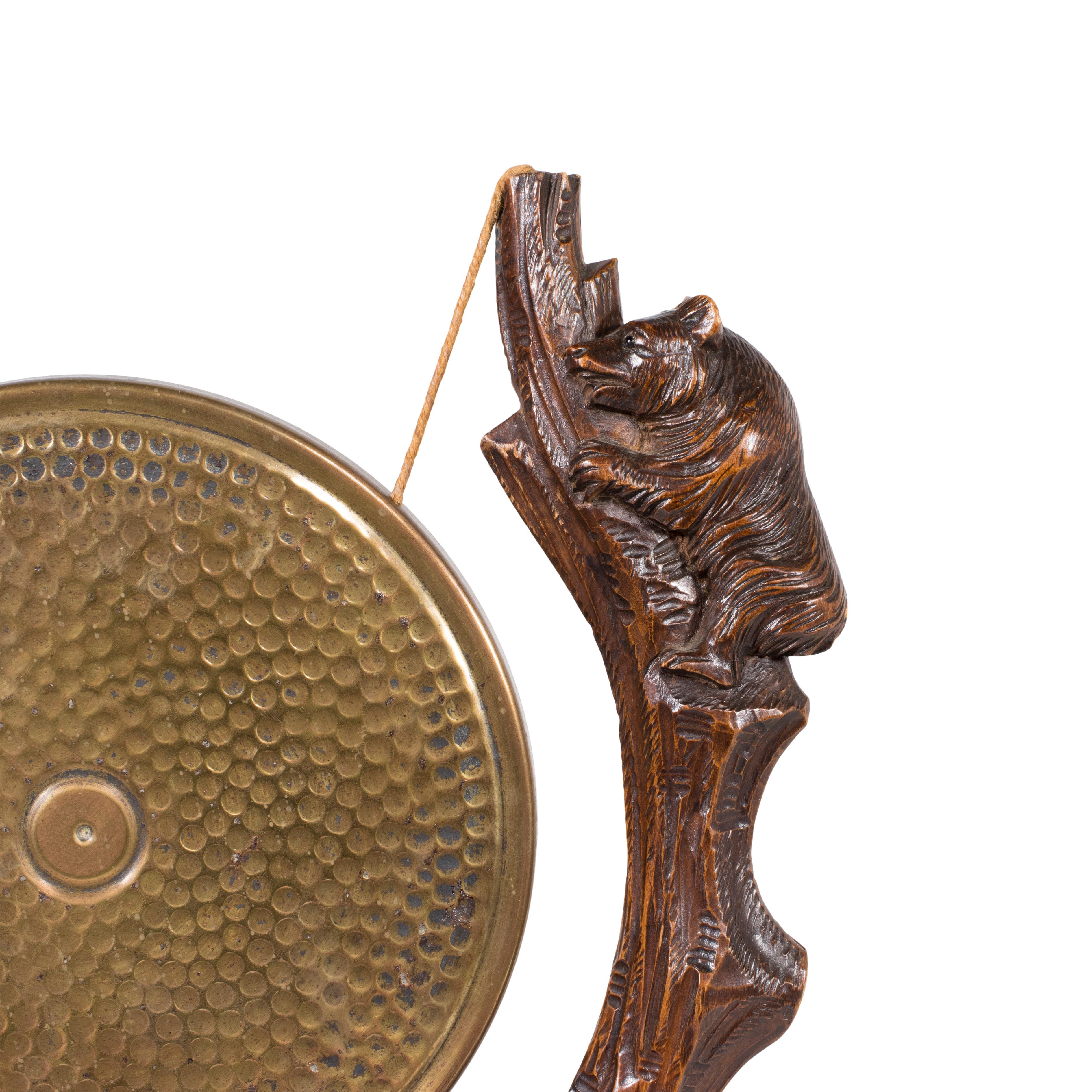 Gong de table en laiton sculpté de la Forêt Noire suisse du 19e siècle, suspendu par deux arbres dont chacun est orné d'un ours grimpant sculpté. Un travail très soigné et unique de la Forêt Noire. Véritable et authentique. 

Période : Premier quart