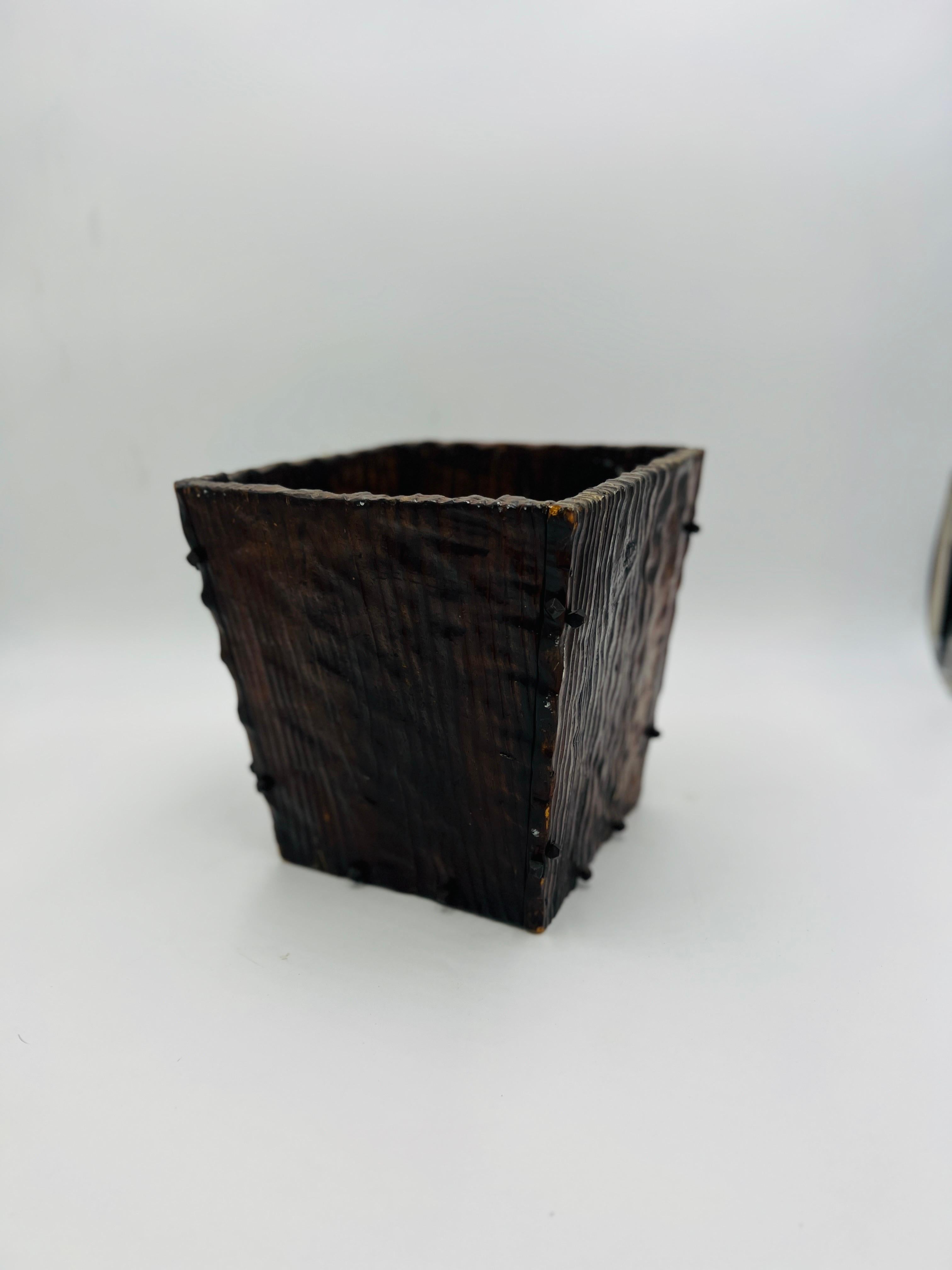 An antique 19th century German black forest waste paper basket or trash can. Constructed likely from walnut and mounted with hand forged iron pins. Faux bois finished across surface.
