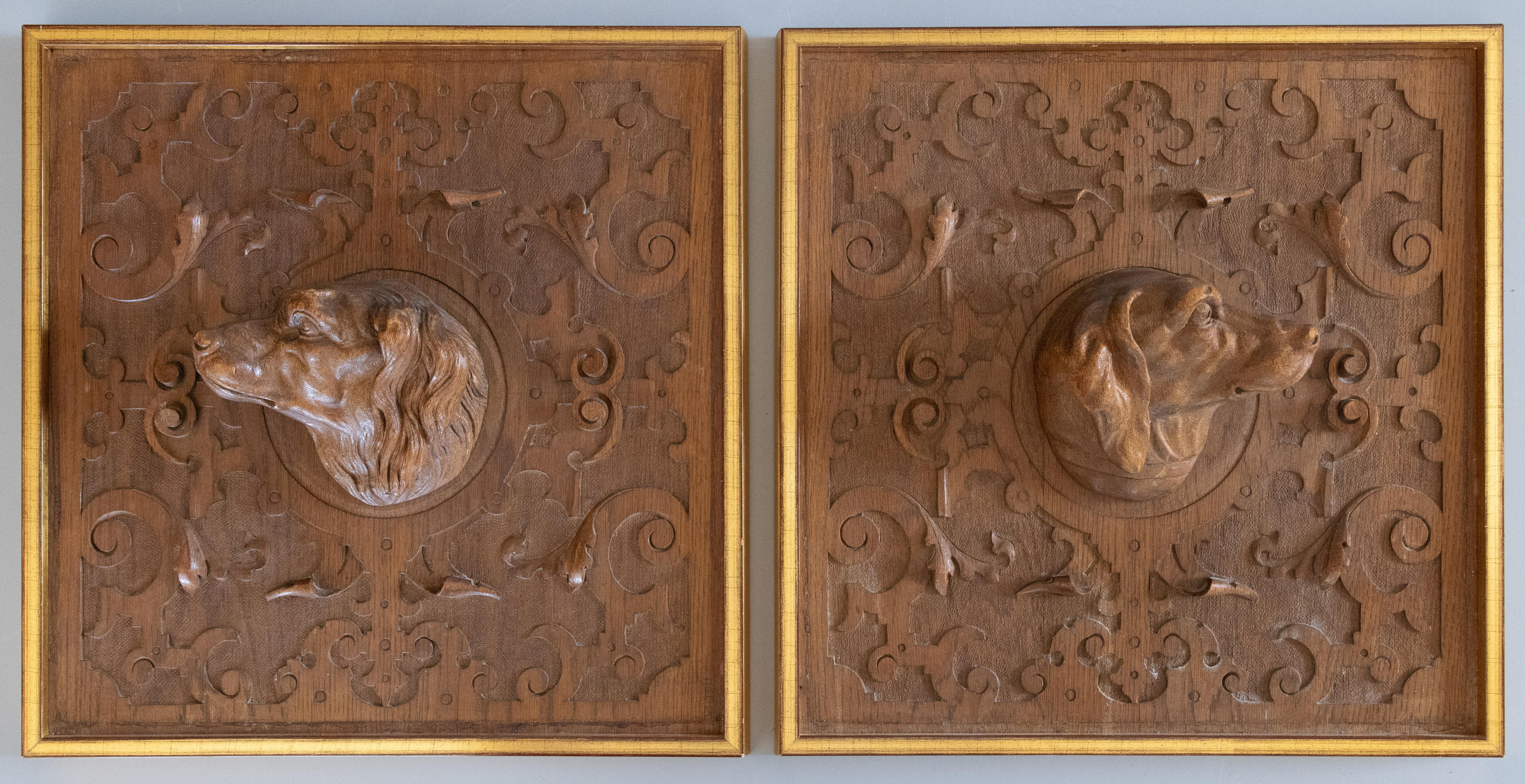 A handsome pair of antique Black Forest hunting dog panels featuring hand carved daschunds in high relief; surrounded by additional ornamental relief. Custom mounted in gold gilt frames. Rare to find a pair in such marvelous
