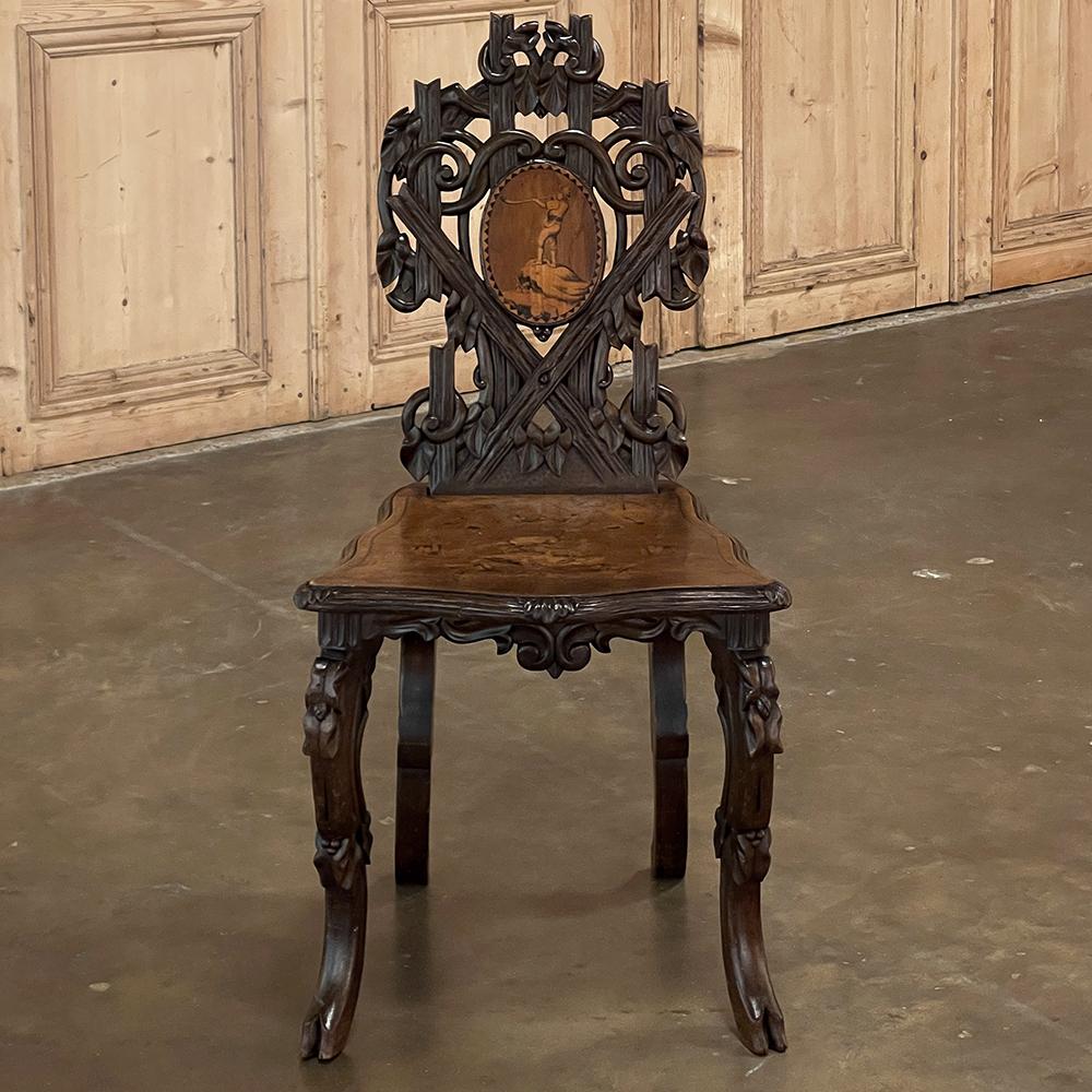 19th century Black Forest carved & inlaid salon chair is a masterpiece of the furniture maker's art! Sumptuous walnut was artfully carved to resemble naturalistic wood as it would appear in the forest, yet constrained into the form of a shield-back