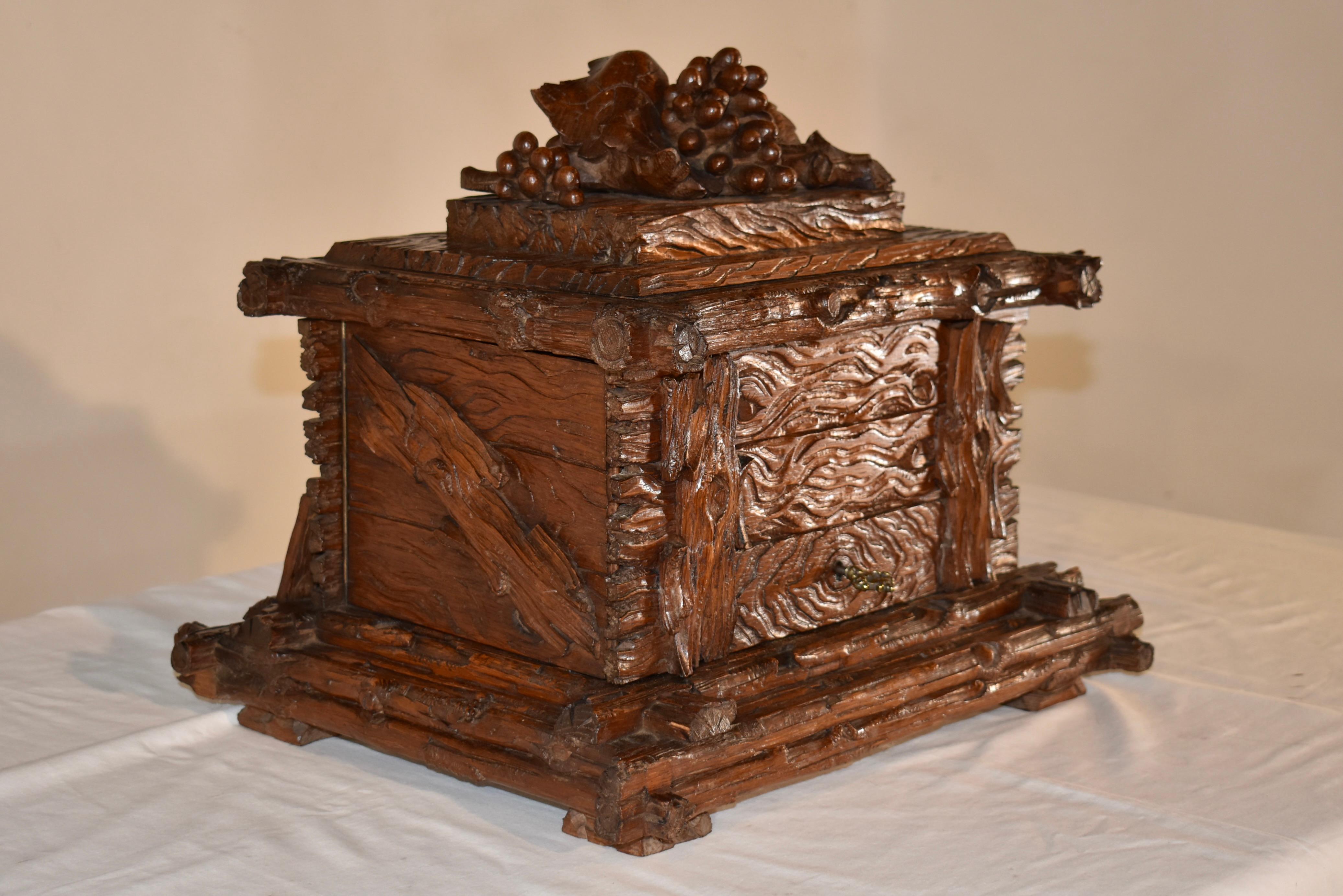 19th Century Black Forest carved liquor set.  The exterior of the box is hand-carved in design as a wood log cabinet, the rectangular Black Forest tantalus is decorated on the top with gorgeous hand carved leaf and grape motifs. Each side, top door