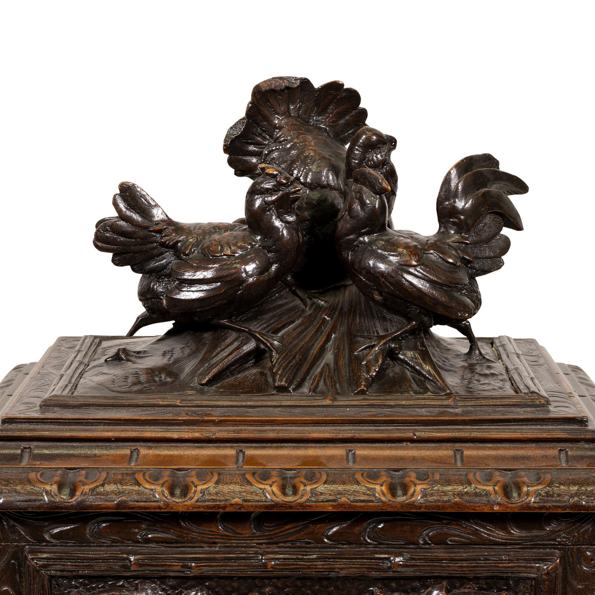Heavily carved container with grape vines and grapes on sides and two game birds with strutting gobler as finial on top. Double hinged lids, two hinged side doors. Original key. Holds ten glasses and two cruets. The serving tray is removable. Came
